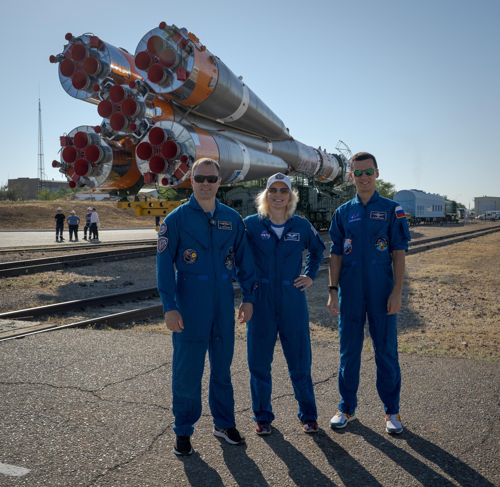 Expedition 75 backup crewmembers: Roscosmos cosmonaut Dmitry Petelin, left, NASA astronuaut Deniz Burnham, and Roscosmos cosmonaut Konstantin Borisov, right, pose for a group photograph as the Soyuz rocket is rolled out by train to the launch pad, Saturday, July 11, 2026, at Site 31 of the Baikonur Cosmodrome in Kazakhstan. Expedition 75 crewmembers: NASA astronaut Anil Menon, Roscosmos cosmonauts Pyotr Dubrov and Anna Kikina are scheduled to launch aboard their Soyuz MS-29 spacecraft on July 14. Photo Credit: (NASA/Bill Ingalls)