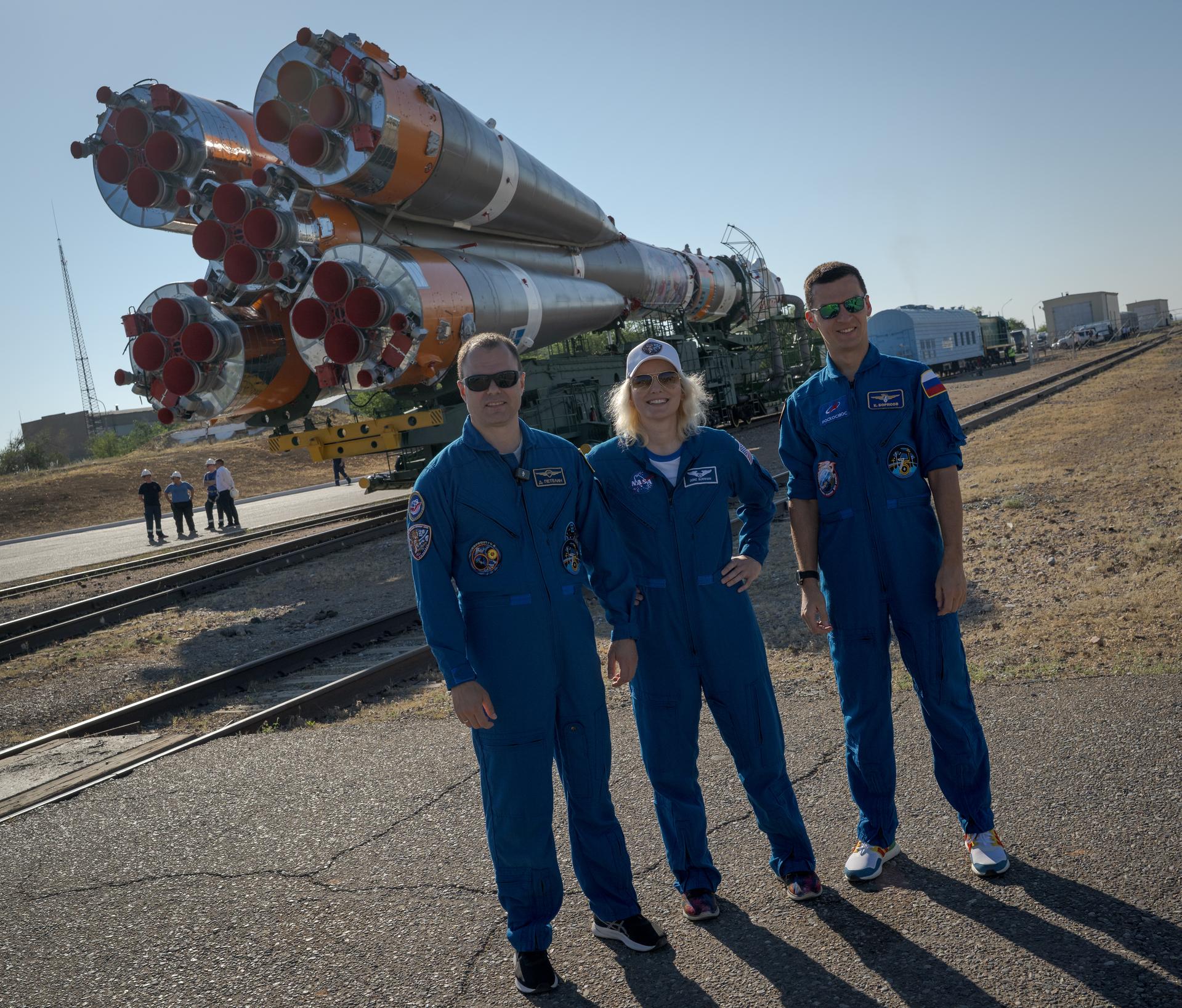 Expedition 75 backup crewmembers: Roscosmos cosmonaut Dmitry Petelin, left, NASA astronuaut Deniz Burnham, and Roscosmos cosmonaut Konstantin Borisov, right, pose for a group photograph as the Soyuz rocket is rolled out by train to the launch pad, Saturday, July 11, 2026, at Site 31 of the Baikonur Cosmodrome in Kazakhstan. Expedition 75 crewmembers: NASA astronaut Anil Menon, Roscosmos cosmonauts Pyotr Dubrov and Anna Kikina are scheduled to launch aboard their Soyuz MS-29 spacecraft on July 14. Photo Credit: (NASA/Bill Ingalls)