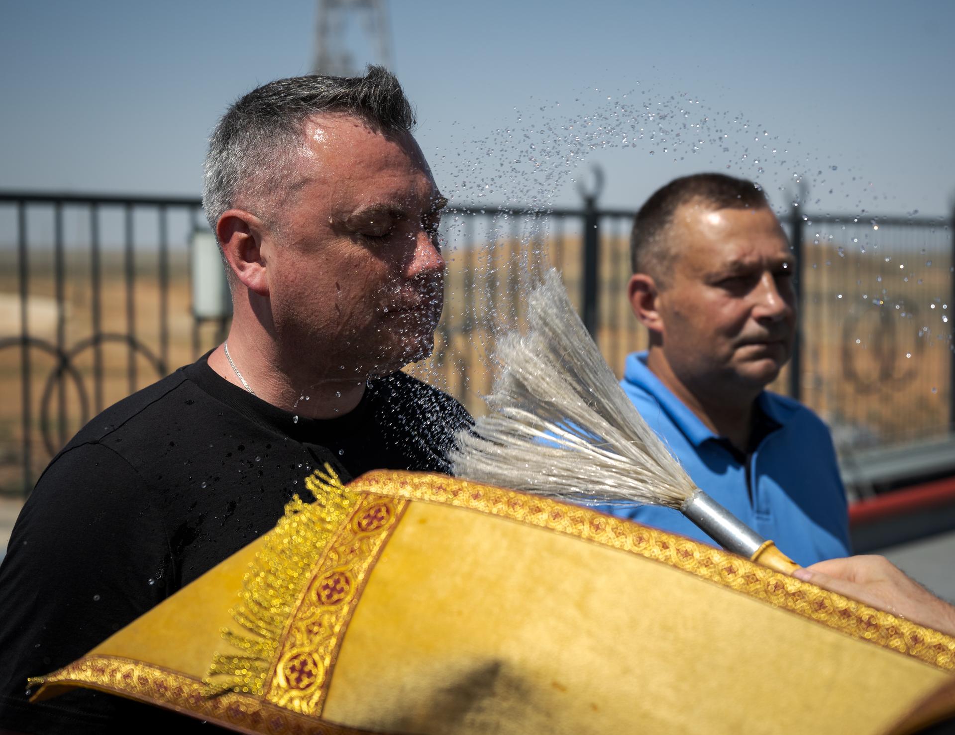 Russian Orthodox Priest blesses members of the launch team, after having blessed the Soyuz rocket, Monday, July 13, 2026 at the Baikonur Cosmodrome Site 31 launch pad in Kazakhstan. Expedition 75 crewmembers: NASA astronaut Anil Menon, Roscosmos cosmonauts Pyotr Dubrov and Anna Kikina are scheduled to launch aboard the Soyuz MS-29 spacecraft to the International Space Station on July 14. Photo Credit: (NASA/Bill Ingalls)