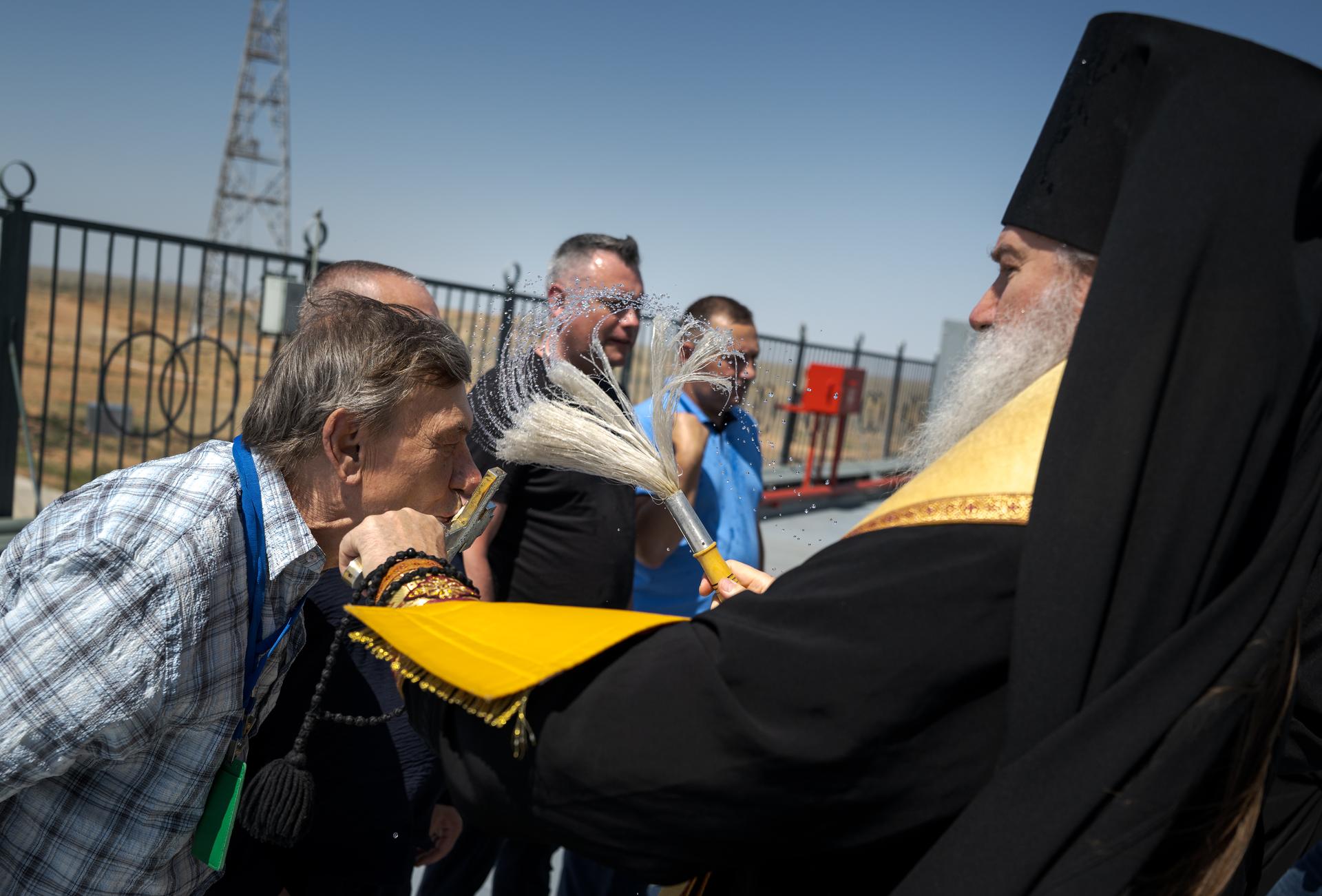 Russian Orthodox Priest blesses members of the launch team, after having blessed the Soyuz rocket, Monday, July 13, 2026 at the Baikonur Cosmodrome Site 31 launch pad in Kazakhstan. Expedition 75 crewmembers: NASA astronaut Anil Menon, Roscosmos cosmonauts Pyotr Dubrov and Anna Kikina are scheduled to launch aboard the Soyuz MS-29 spacecraft to the International Space Station on July 14. Photo Credit: (NASA/Bill Ingalls)