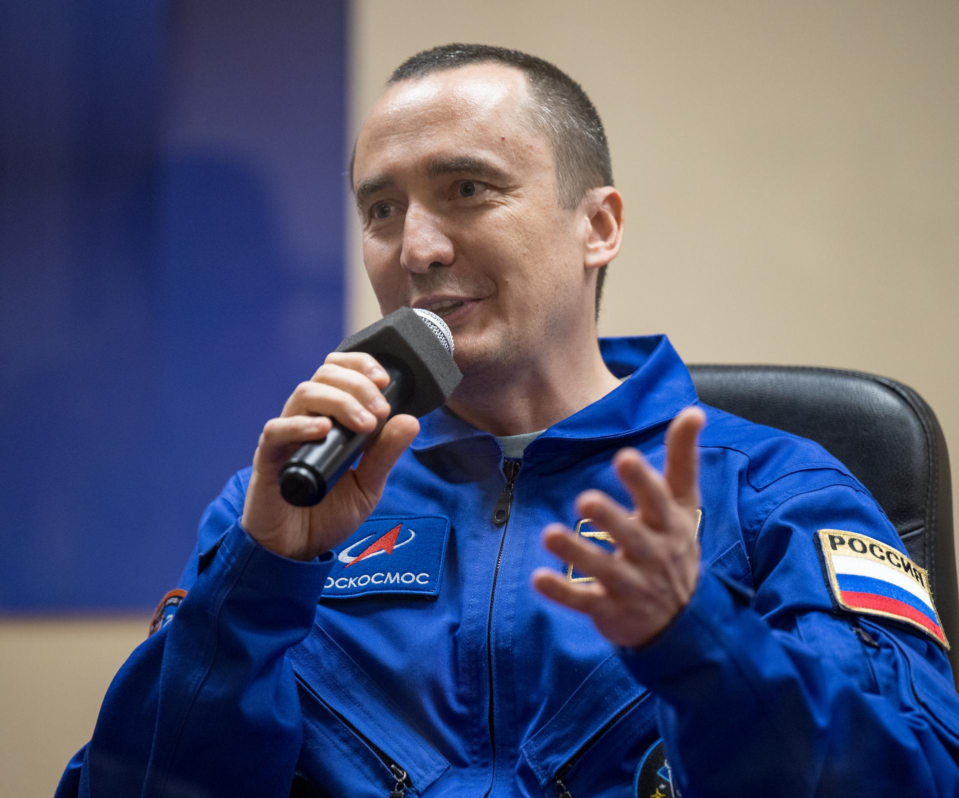 Roscosmos cosmonaut Pyotr Dubrov is seen in quarantine, behind glass, during a press conference, Monday, July 13, 2026 a the Cosmonaut Hotel in Baikonur, Kazakhstan. Expedition 75 crewmembers: NASA astronaut Anil Menon, Roscosmos cosmonauts Pyotr Dubrov and Anna Kikina are scheduled to launch aboard the Soyuz MS-29 spacecraft to the International Space Station on July 14. Photo Credit: (NASA/Bill Ingalls)