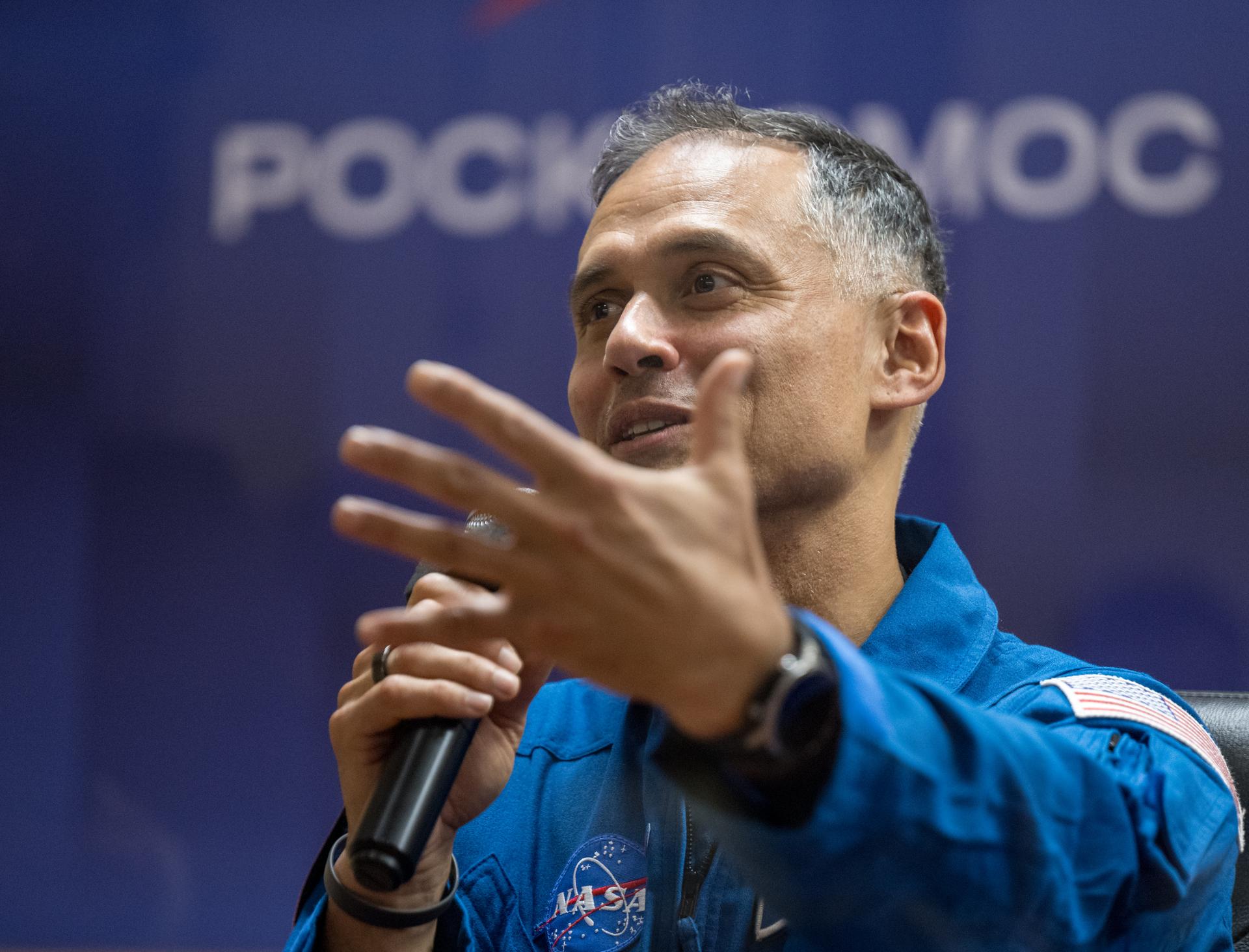 NASA astronaut Anil Menon is seen in quarantine, behind glass, during a press conference, Monday, July 13, 2026 a the Cosmonaut Hotel in Baikonur, Kazakhstan. Expedition 75 crewmembers: NASA astronaut Anil Menon, Roscosmos cosmonauts Pyotr Dubrov and Anna Kikina are scheduled to launch aboard the Soyuz MS-29 spacecraft to the International Space Station on July 14. Photo Credit: (NASA/Bill Ingalls)