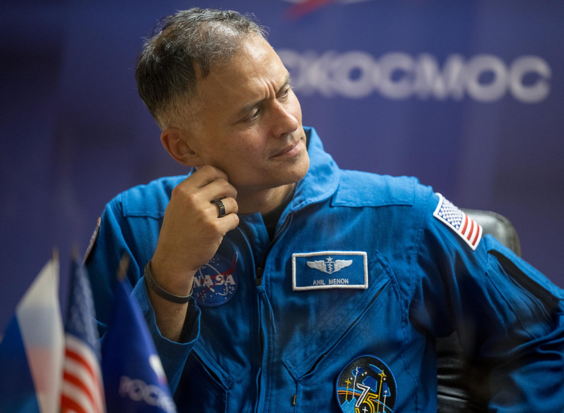 NASA astronaut Anil Menon is seen in quarantine, behind glass, during a press conference, Monday, July 13, 2026 a the Cosmonaut Hotel in Baikonur, Kazakhstan. Expedition 75 crewmembers: NASA astronaut Anil Menon, Roscosmos cosmonauts Pyotr Dubrov and Anna Kikina are scheduled to launch aboard the Soyuz MS-29 spacecraft to the International Space Station on July 14. Photo Credit: (NASA/Bill Ingalls)