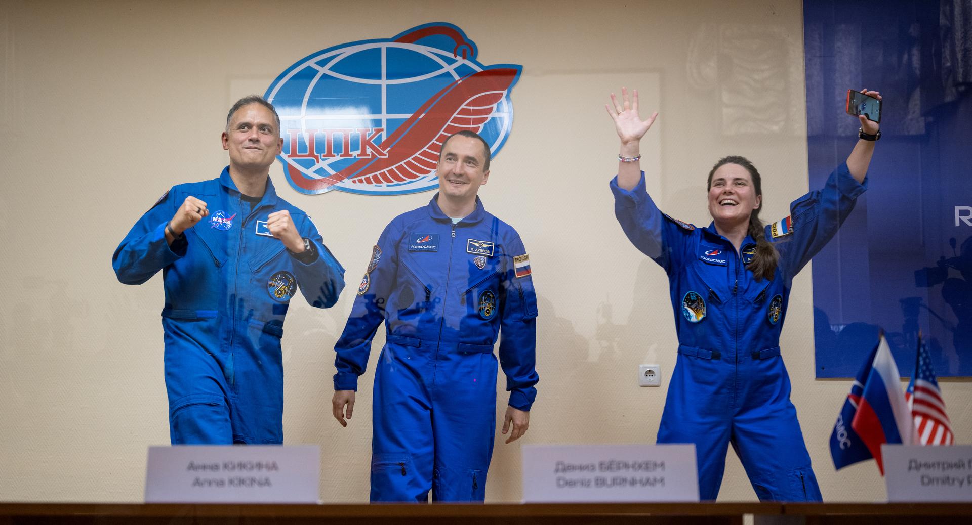 Expedition 75 crewmembers: NASA astronaut Anil Menon, left, Roscosmos cosmonauts Pyotr Dubrov, and Anna Kikina, right, are seen in quarantine, behind glass, during a press conference, Monday, July 13, 2026 a the Cosmonaut Hotel in Baikonur, Kazakhstan. Menon, Dubrov, and Kikina are scheduled to launch aboard the Soyuz MS-29 spacecraft to the International Space Station on July 14. Photo Credit: (NASA/Bill Ingalls)