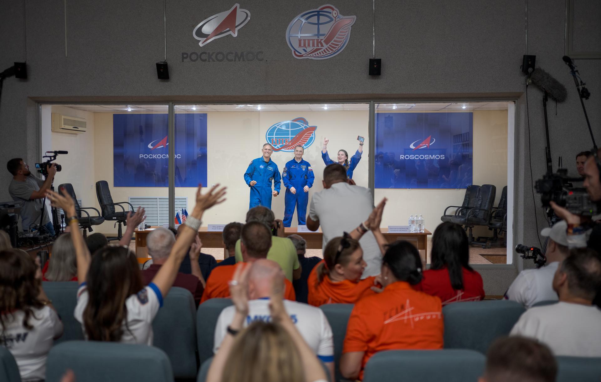 Expedition 75 crewmembers: NASA astronaut Anil Menon, left, Roscosmos cosmonauts Pyotr Dubrov, and Anna Kikina, right, are seen in quarantine, behind glass, during a press conference, Monday, July 13, 2026 a the Cosmonaut Hotel in Baikonur, Kazakhstan. Menon, Dubrov, and Kikina are scheduled to launch aboard the Soyuz MS-29 spacecraft to the International Space Station on July 14. Photo Credit: (NASA/Bill Ingalls)