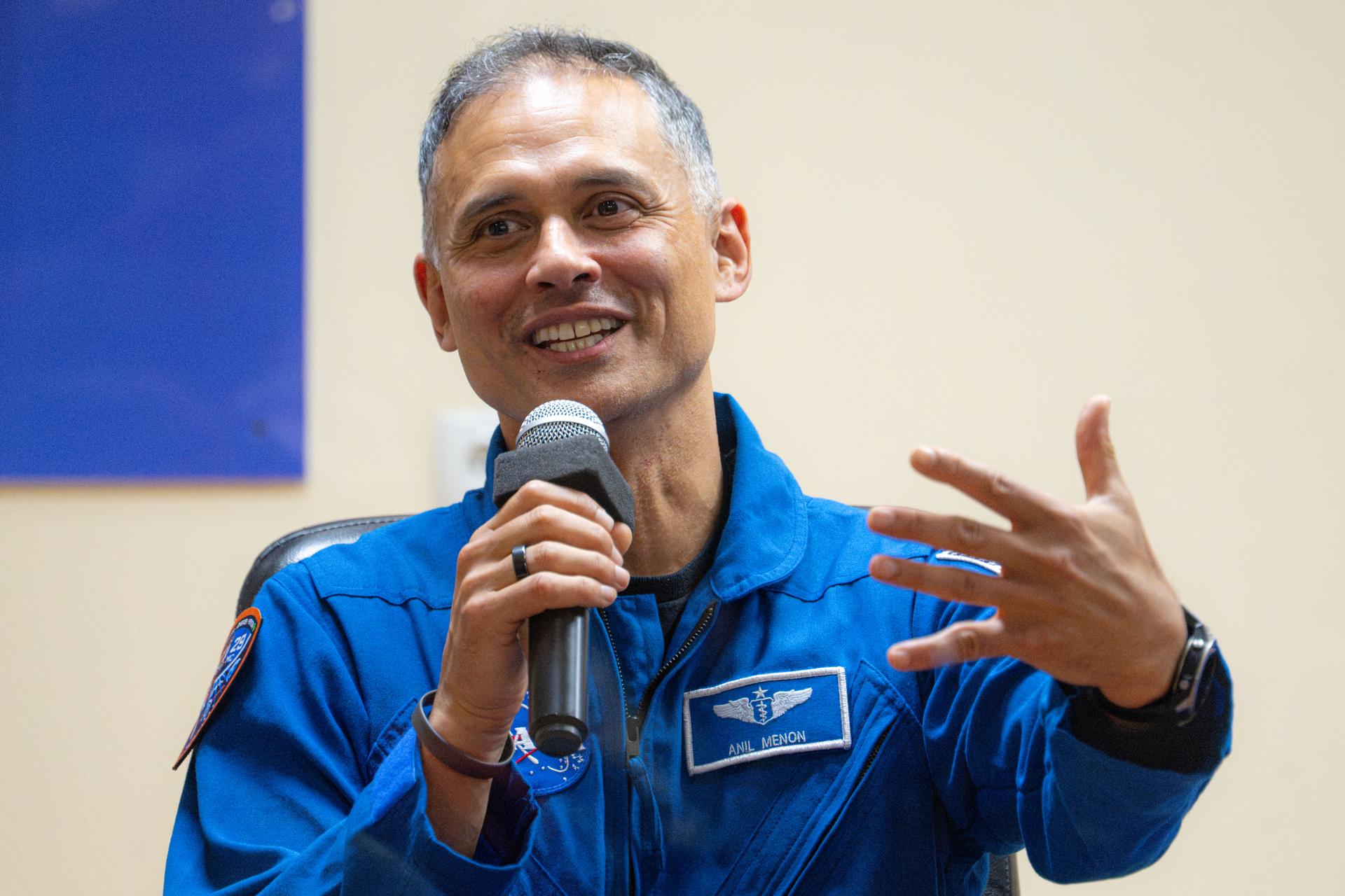 NASA astronaut Anil Menon is seen in quarantine, behind glass, during a press conference, Monday, July 13, 2026, at the Cosmonaut Hotel in Baikonur, Kazakhstan. Expedition 75 crewmembers NASA astronaut Anil Menon and Roscosmos cosmonauts Pyotr Dubrov and Anna Kikina are scheduled to launch aboard the Soyuz MS-29 spacecraft to the International Space Station on July 14. Photo Credit: (NASA/John Kraus)