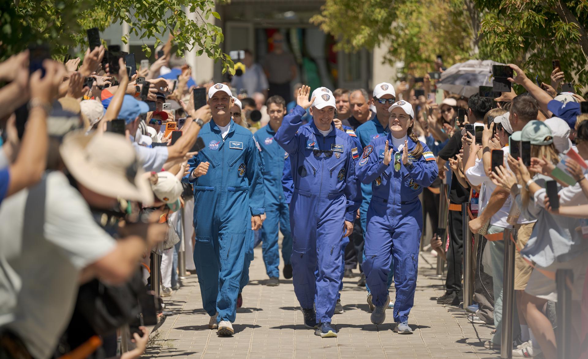 Expedition 75 crew members: NASA astronaut Anil Menon, left, Roscosmos cosmonauts Pyotr Dubrov, and Anna Kikina, right, depart the Cosmonaut Hotel to suit-up for their Soyuz launch, Tuesday, July 14, 2026, in Baikonur, Kazakhstan. The launch will send Menon, Dubrov, and Kikina on a mission to the International Space Station. Photo Credit: (NASA/Bill Ingalls)