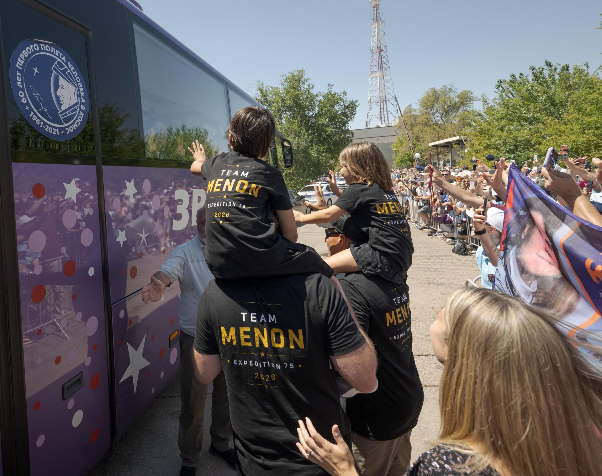Family and friends wave farewell to Expedition 75 crew members: NASA astronaut Anil Menon, Roscosmos cosmonauts Pyotr Dubrov, and Anna Kikina, as they depart the Cosmonaut Hotel to suit-up for their Soyuz launch, Tuesday, July 14, 2026, in Baikonur, Kazakhstan. The launch will send Menon, Dubrov, and Kikina on a mission to the International Space Station. Photo Credit: (NASA/Bill Ingalls)
