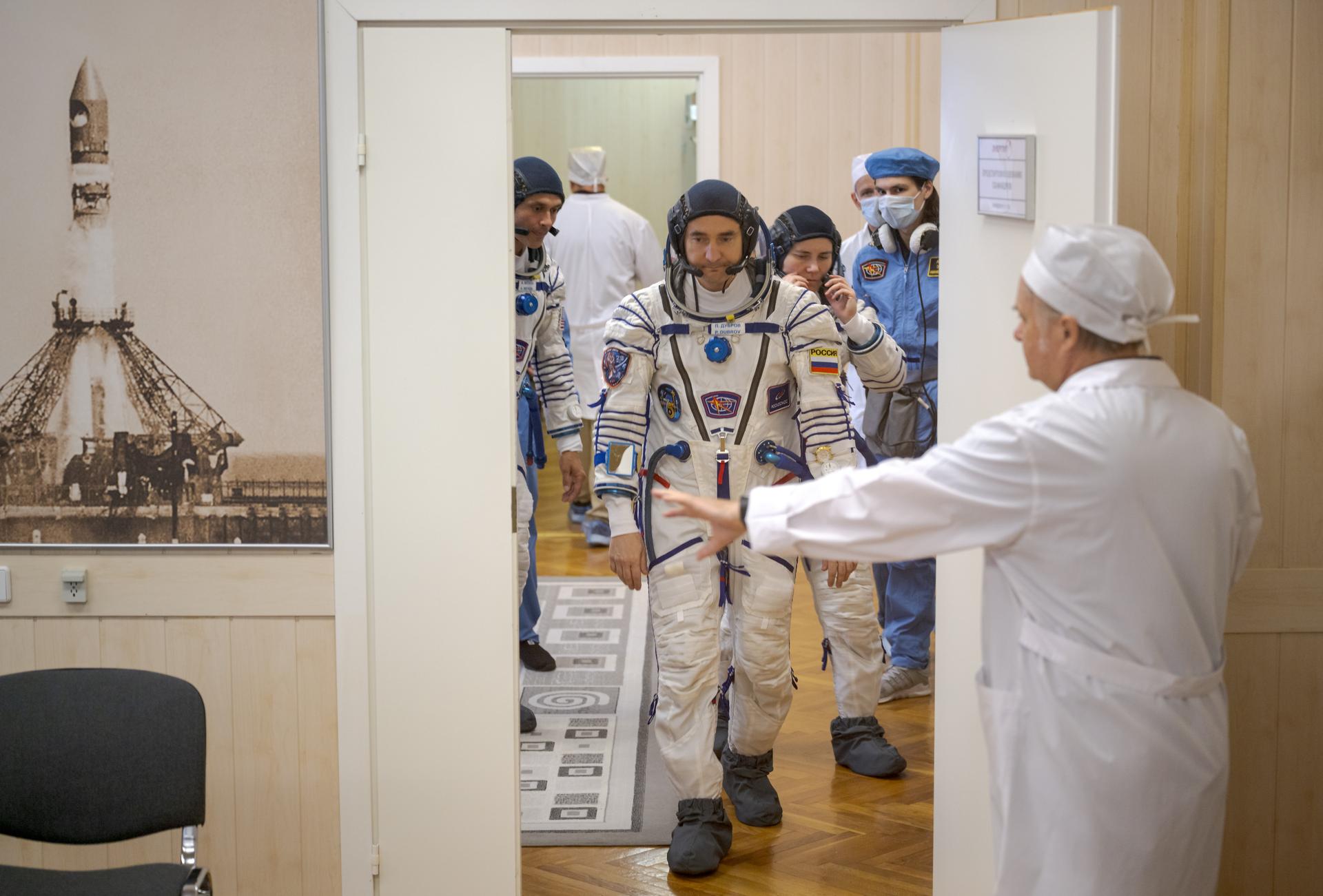 Expedition 75 crew members: NASA astronaut Anil Menon, left, Roscosmos cosmonauts Pyotr Dubrov, and Anna Kikina, right, prepare to have their Russian Sokol suits pressure checked as they ready for their Soyuz launch to the International Space Station Tuesday, July 14, 2026 in Baikonur, Kazakhstan. Photo Credit: (NASA/Bill Ingalls)