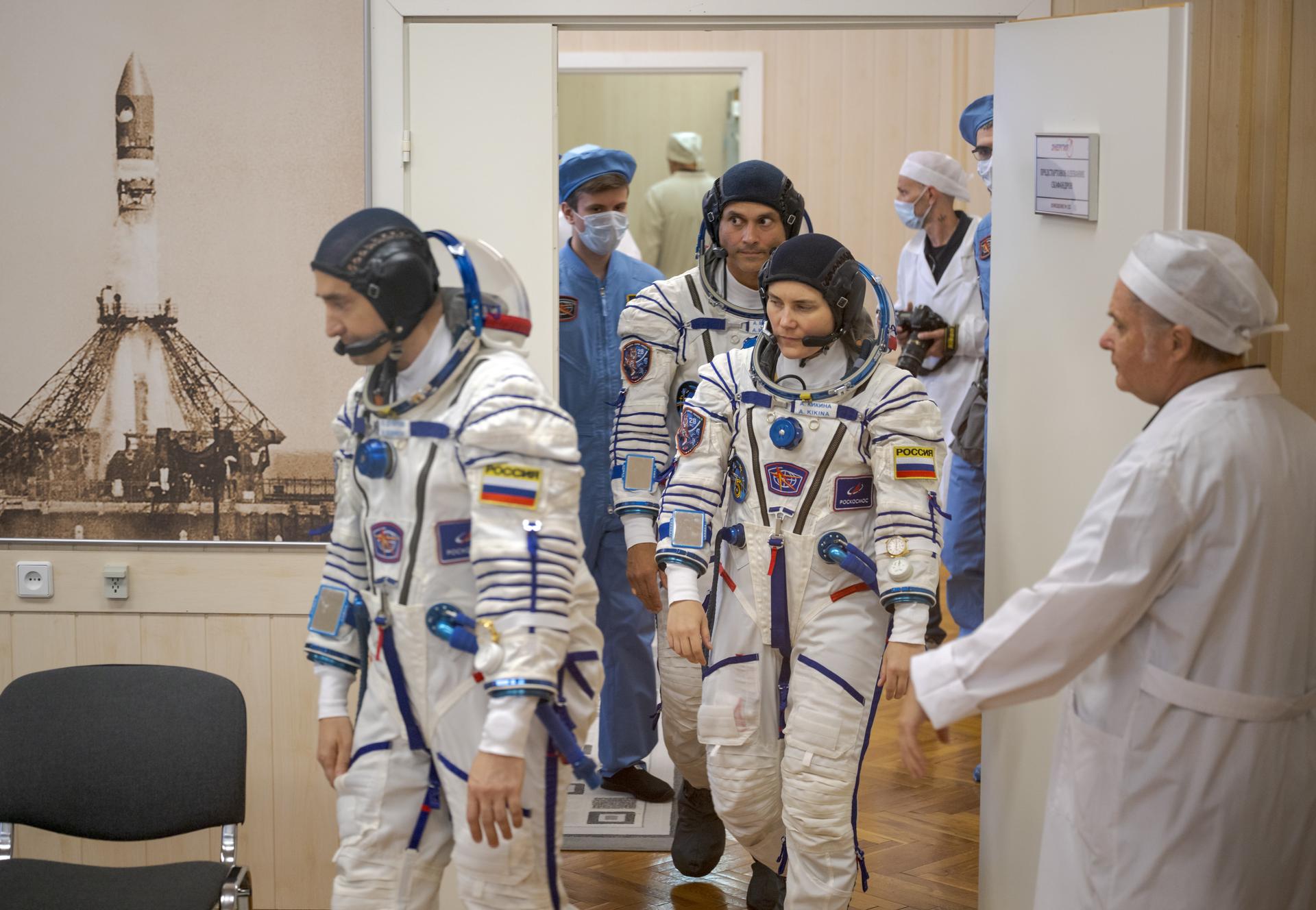 Expedition 75 crew members: Roscosmos cosmonauts Pyotr Dubrov, foreground, Anna Kikina, and NASA astronaut Anil Menon, background, prepare to have their Russian Sokol suits pressure checked as they ready for their Soyuz launch to the International Space Station Tuesday, July 14, 2026 in Baikonur, Kazakhstan. Photo Credit: (NASA/Bill Ingalls)
