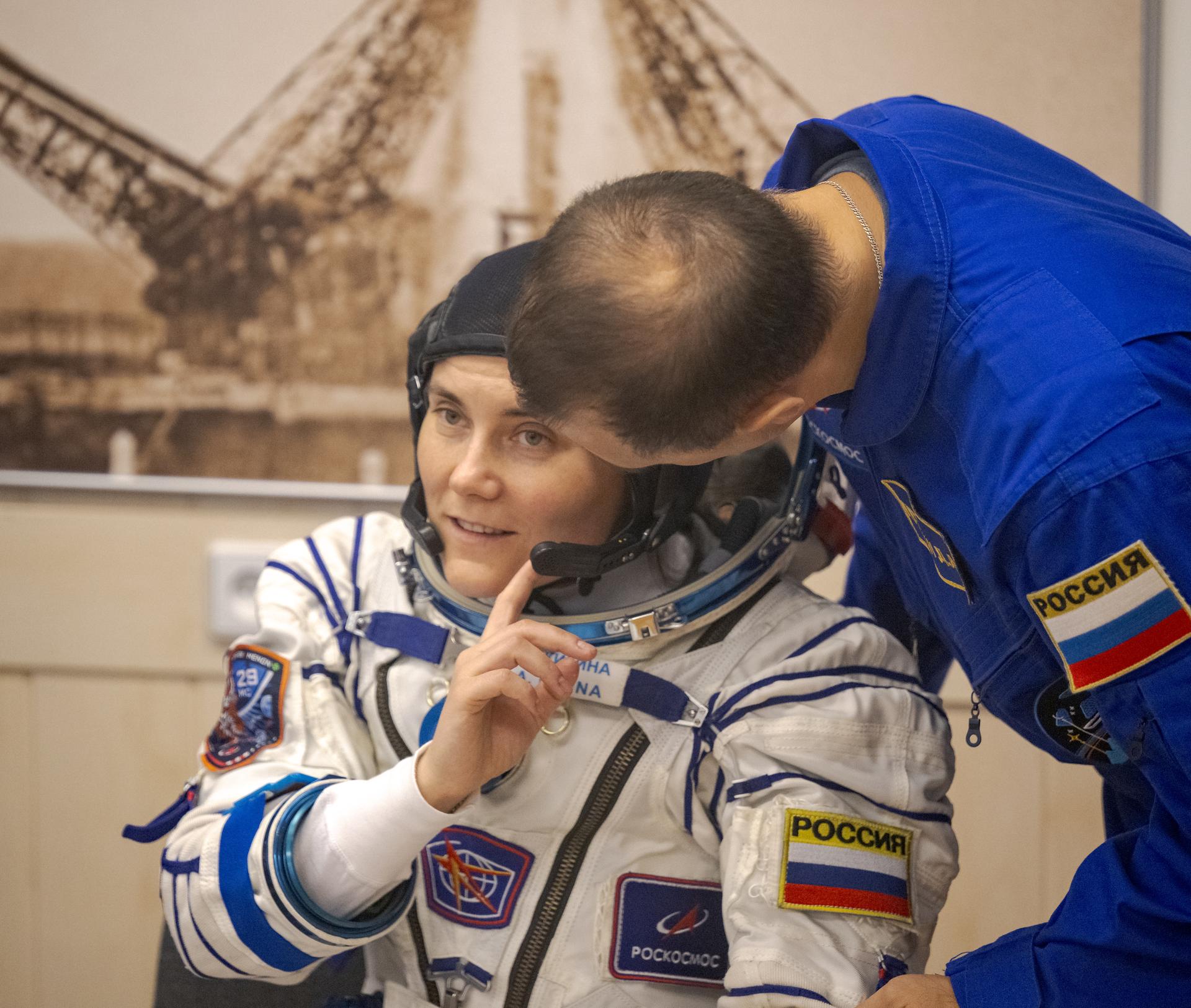 Roscosmos cosmonaut Anna Kikina talks with backup crew member Roscosmos cosmonaut Dmitry Petelin while waiting to have her Russian Sokol Suit pressure checked, as she and fellow crewmates, Roscosmos cosmonaut Pyotr Dubrov, and NASA astronaut Anil Menon, prepare for their Soyuz launch to the International Space Station Tuesday, July 14, 2026 in Baikonur, Kazakhstan. Photo Credit: (NASA/Bill Ingalls)