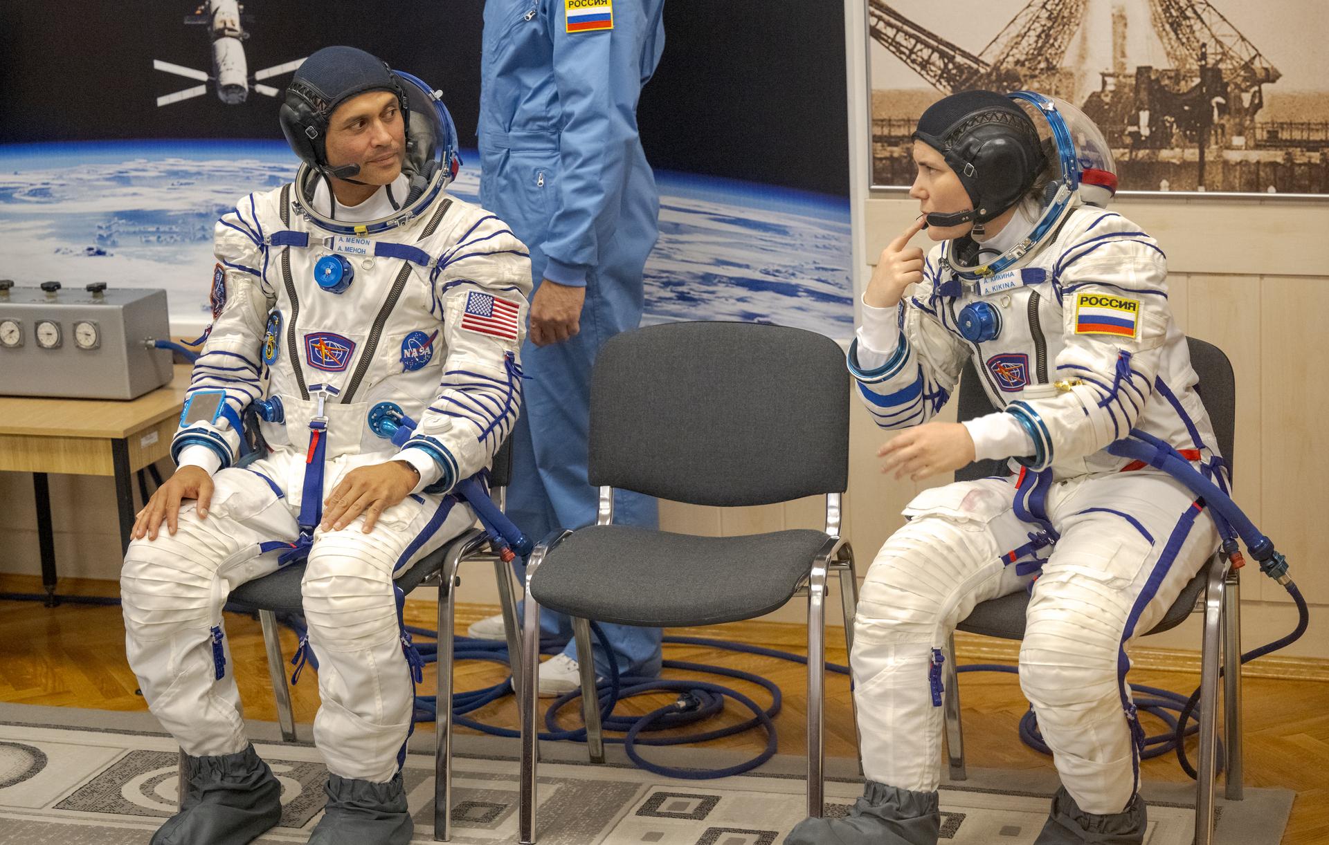 Expedition 75 NASA astronaut Anil Menon, left, and Roscosmos cosmonaut Anna Kikina wait to have their Russian Sokol Suits pressure checked, as they and fellow crewmate, Roscosmos cosmonaut Pyotr Dubrov, prepare for their Soyuz launch to the International Space Station Tuesday, July 14, 2026 in Baikonur, Kazakhstan. Photo Credit: (NASA/Bill Ingalls)