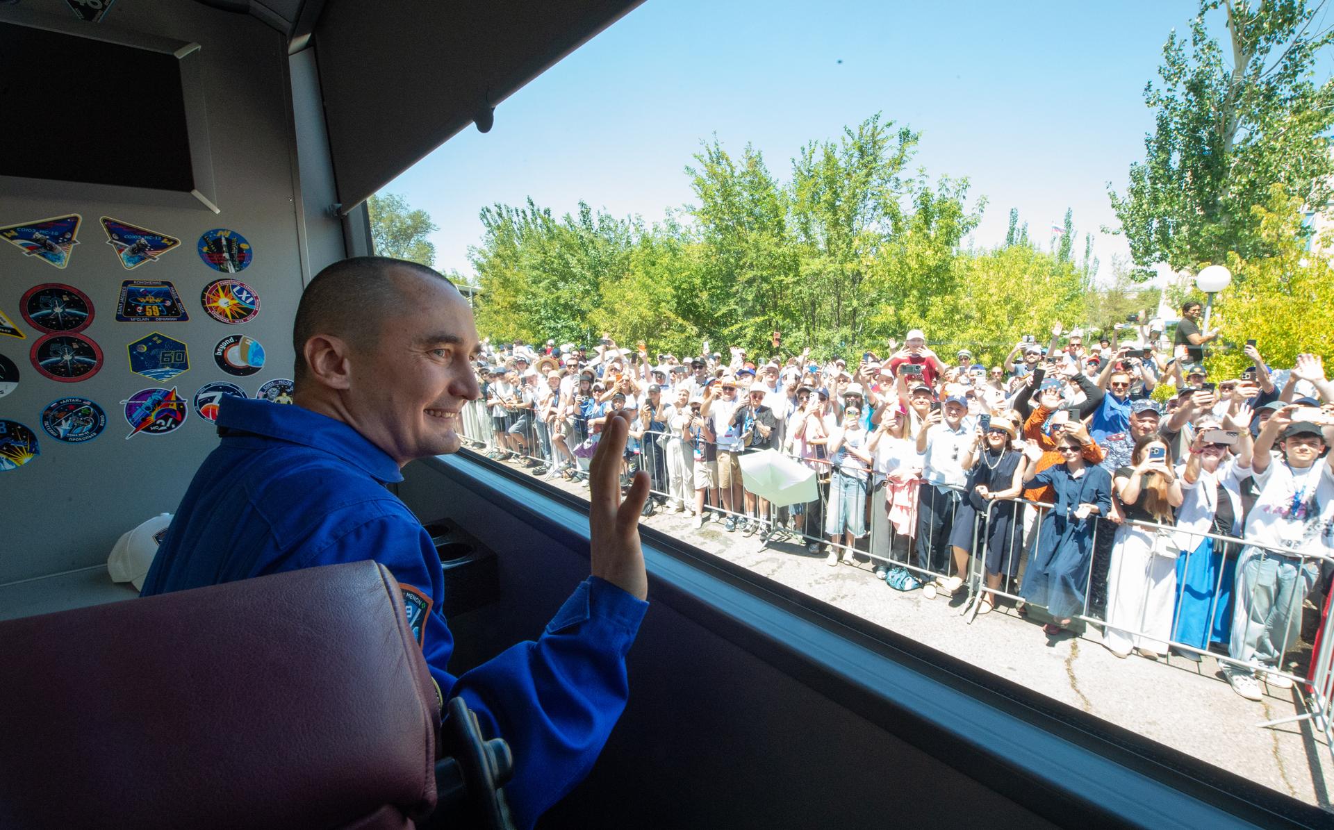 Expedition 75 Roscosmos cosmonaut Pyotr Dubrov waves as he departs the Cosmonaut Hotel with crew mates Roscosmos cosmonaut Anna Kikina, and NASA astronaut Anil Menon, to suit-up for their Soyuz launch, Tuesday, July 14, 2026, in Baikonur, Kazakhstan. The launch will send Menon, Dubrov, and Kikina on a mission to the International Space Station. Photo Credit: (NASA/GCTC/Pavel Shvets)