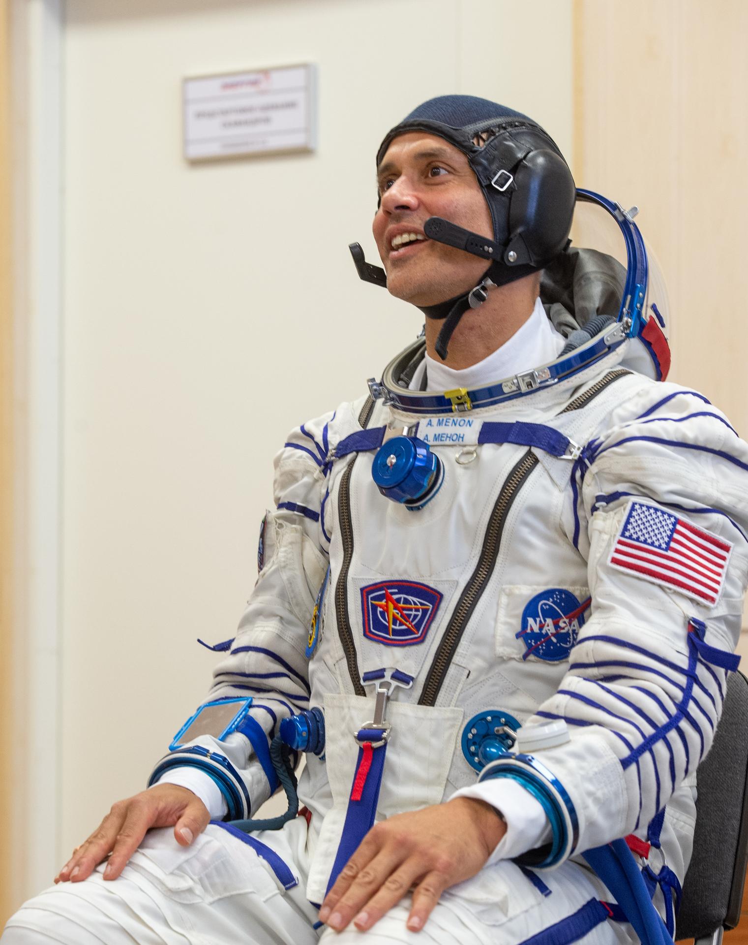 Expedition 75 NASA astronaut Anil Menon is helped into his Russian Sokol suit as he and fellow crew mates, Roscosmos cosmonauts Pyotr Dubrov, and Anna Kikina, prepare for their Soyuz launch to the International Space Station Tuesday, July 14, 2026 in Baikonur, Kazakhstan. The launch will send Menon, Dubrov, and Kikina on a mission to the International Space Station. Photo Credit: (NASA/GCTC/Pavel Shvets)