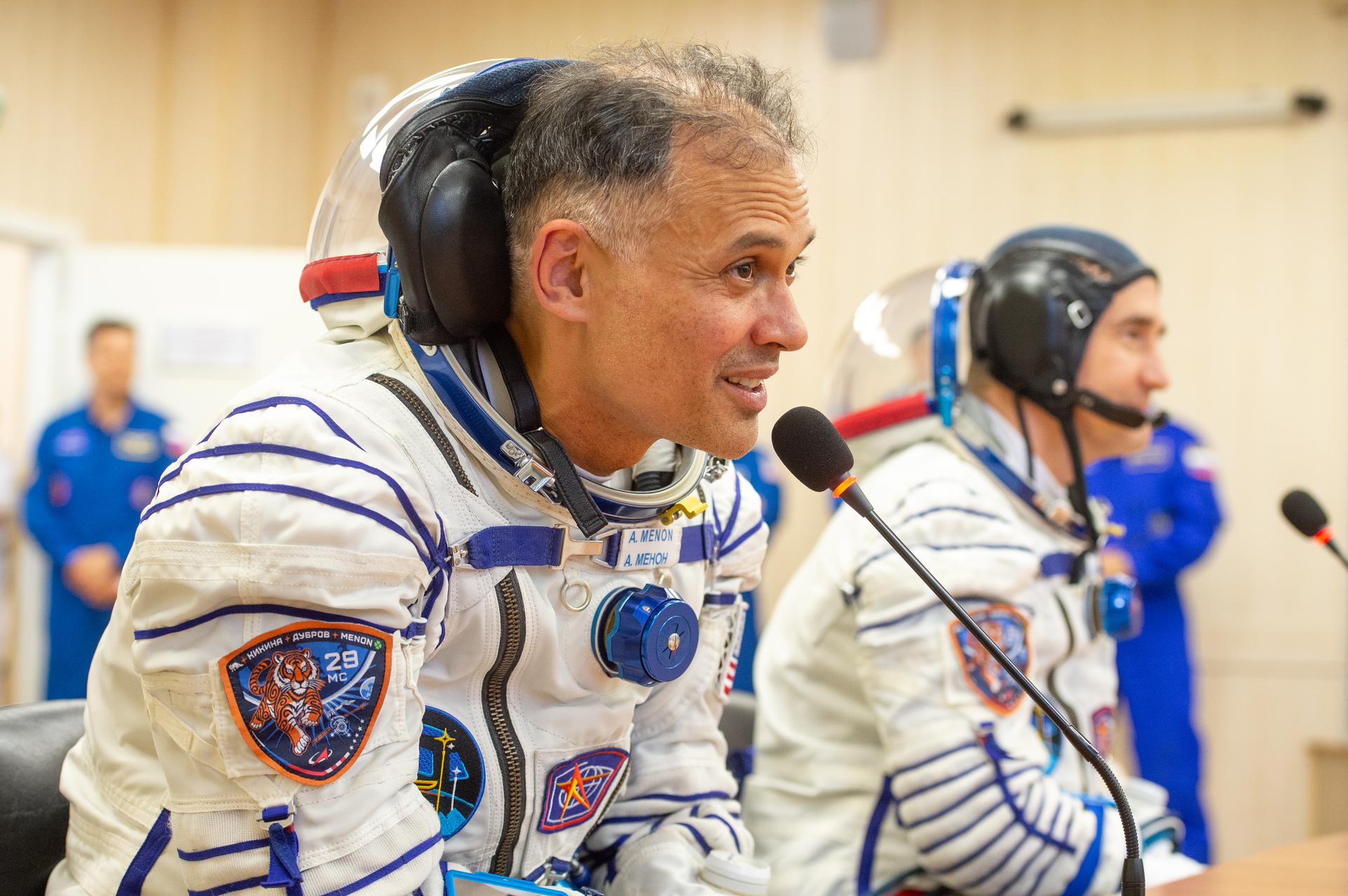 Expedition 75 NASA astronaut Anil Menon, left, and Roscosmos cosmonaut Pyotr Dubrov, talk to family and friends after they and Roscosmos cosmonaut Anna Kikina had their Russian Sokol suits pressure checked for their Soyuz launch to the International Space Station Tuesday, July 14, 2026 in Baikonur, Kazakhstan. Photo Credit: (NASA/GCTC/Pavel Shvets)