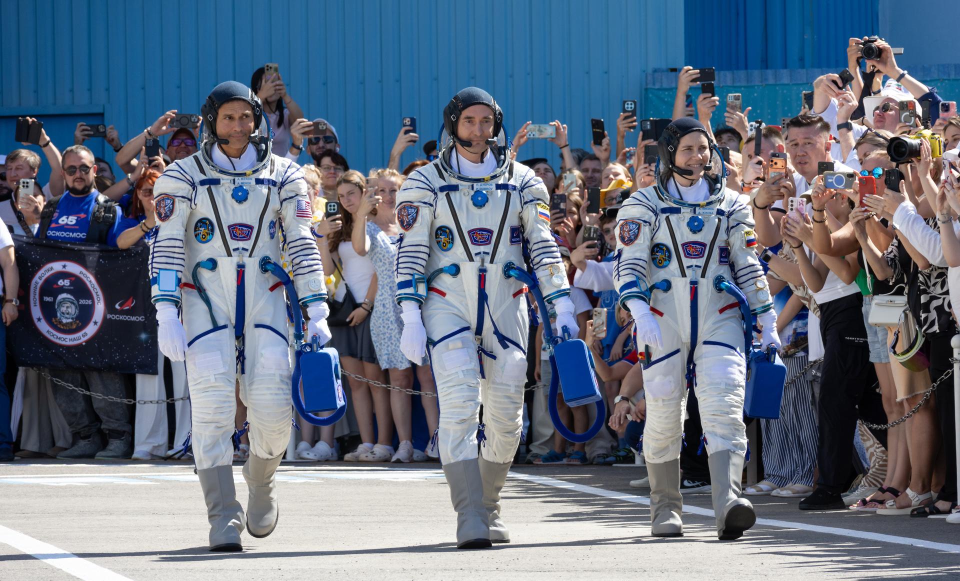 Expedition 75 crewmembers: NASA astronaut Anil Menon, left, Roscosmos cosmonauts Pyotr Dubrov, and Anna Kikina, right, depart building 254 for their Soyuz launch to the International Space Station Tuesday, July 14, 2026 in Baikonur, Kazakhstan. Photo Credit: (NASA/Victor Zelentsov)