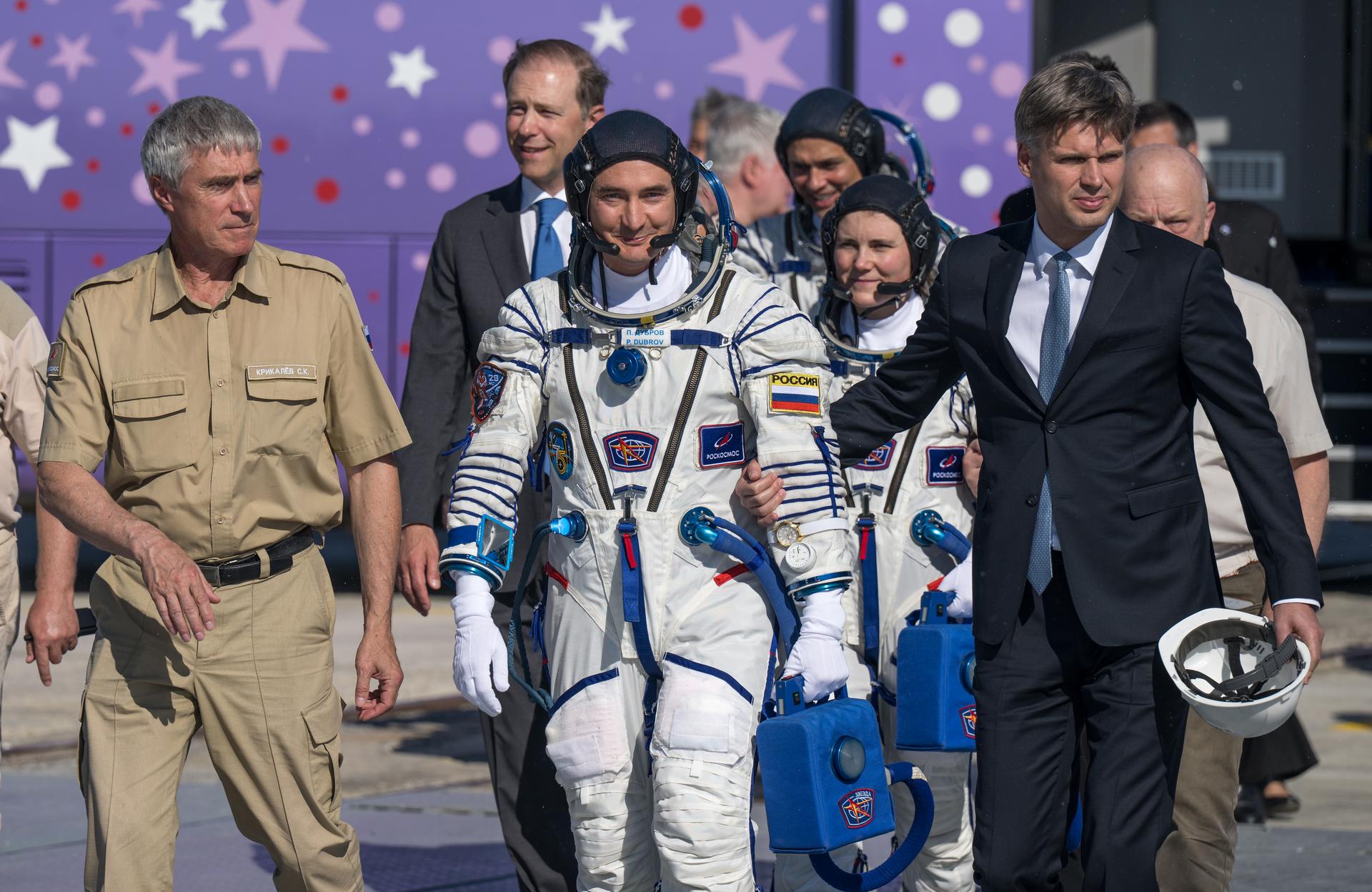 Expedition 75 Roscosmos cosmonaut Pyotr Dubrov walks with Roscosmos Director of Human Spaceflight Programs Sergei Krikalev, left, and Roscosmos Director General Dmitry Bakanov to board the Soyuz MS-29 spacecraft for launch with NASA astronaut Anil Menon, and Roscosmos cosmonaut Anna Kikina, Tuesday, July 14, 2026 at the Baikonur Cosmodrome in Kazakhstan. Launch of the Soyuz rocket will send the trio on a mission to the International Space Station. Photo Credit: (NASA/Bill Ingalls)
