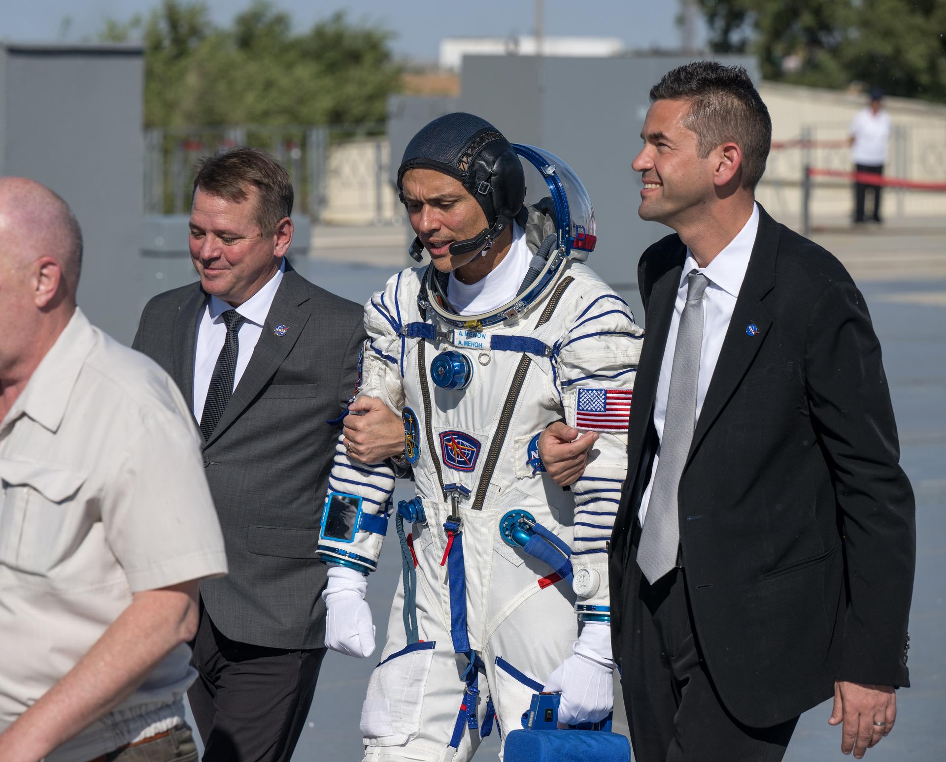 Expedition 75 NASA astronaut Anil Menon walks with NASA Deputy Administrator Matt Anderson, left, and NASA Administrator Jared Isaacman, right, to board the Soyuz MS-29 spacecraft for launch with Roscosmos cosmonauts Anna Kikina, and Pyotr Dubrov, Tuesday, July 14, 2026 at the Baikonur Cosmodrome in Kazakhstan. Launch of the Soyuz rocket will send the trio on a mission to the International Space Station. Photo Credit: (NASA/Bill Ingalls)