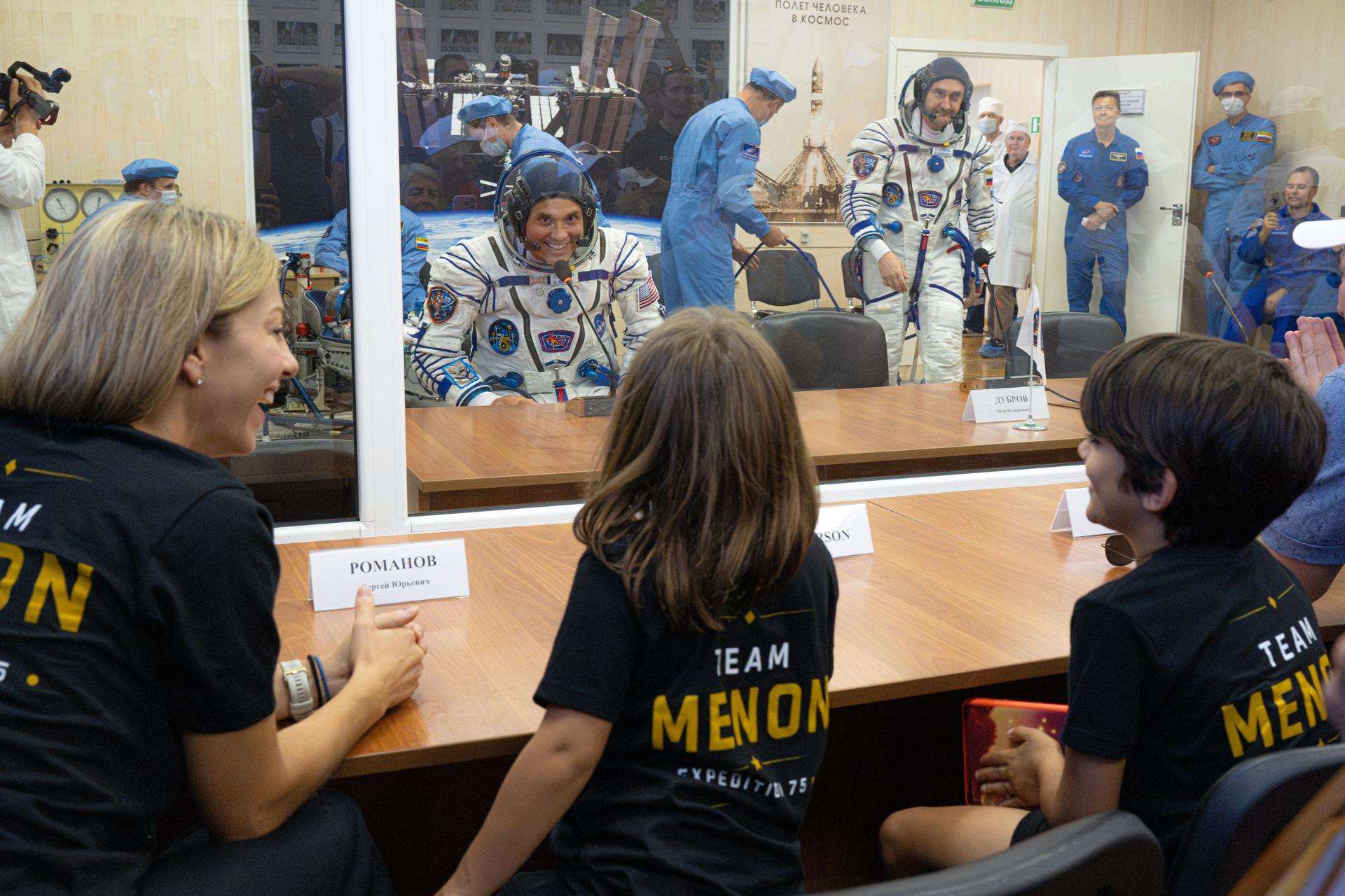 Expedition 75 crewmember NASA astronaut Anil Menon shares a moment with his wife, NASA astronaut candidate Anna Menon, and children following a pressure check of his Russian Sokul suit before launch, Tuesday, July 14, 2026, at the Baikonur Cosmodrome in Kazakhstan. The launch will send NASA astronaut Anil Menon and Roscosmos cosmonauts Pyotr Dubrov and Anna Kikina to the International Space Station aboard the Soyuz MS-29 spacecraft. Photo Credit: (NASA/John Kraus)