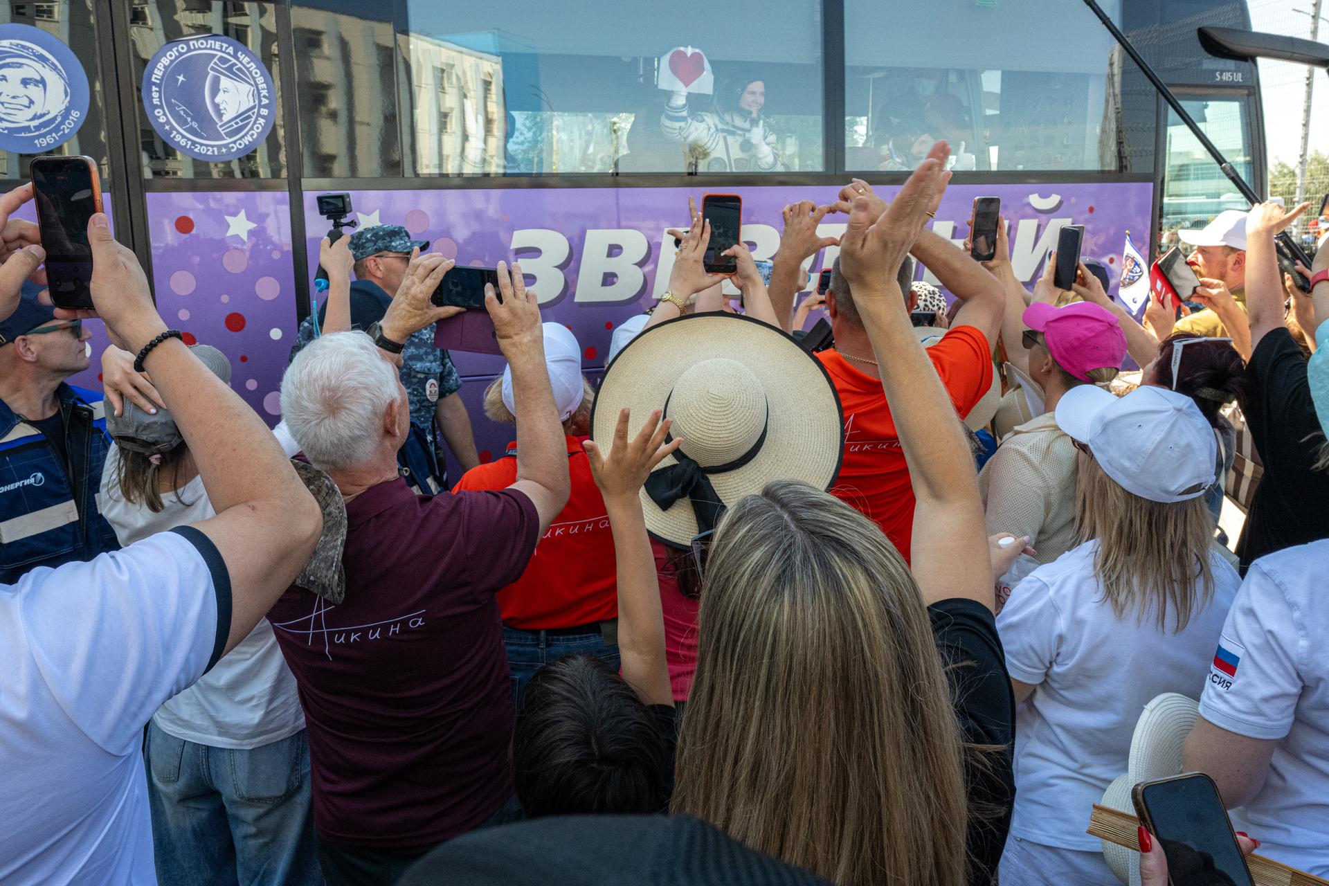 Family members, friends, and guests wave to Expedition 75 crewmembers NASA astronaut Anil Menon and Roscosmos cosmonauts Pyotr Dubrov and Anna Kikina as they depart building 254 before launch, Tuesday, July 14, 2026, at the Baikonur Cosmodrome in Kazakhstan. The launch will send the trio to the International Space Station aboard the Soyuz MS-29 spacecraft. Photo Credit: (NASA/John Kraus)