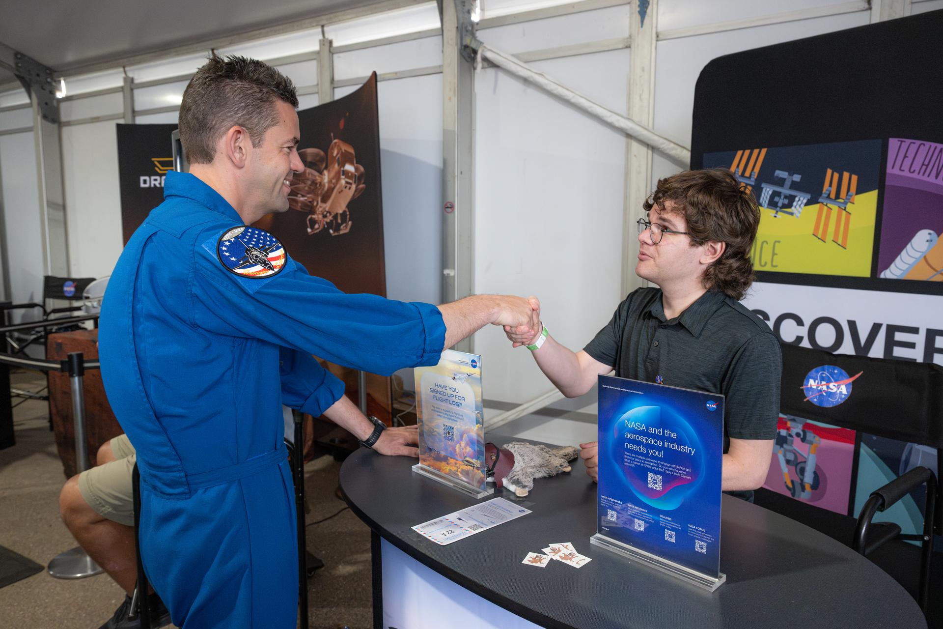 NASA Administrator Jared Isaacman greets a member of the NASA workforce, Friday, July 24, 2026, at NASA's exhibit at EAA AirVenture Oshkosh at Wittman Regional Airport in Oshkosh, Wis. Photo Credit: (NASA/John Kraus)