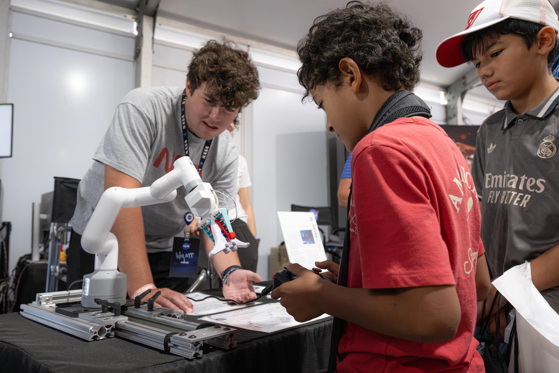 Air show attendees visit NASA's exhibit at EAA AirVenture Oshkosh, Friday, July 24, 2026, at Wittman Regional Airport in Oshkosh, Wis. Photo Credit: (NASA/John Kraus)