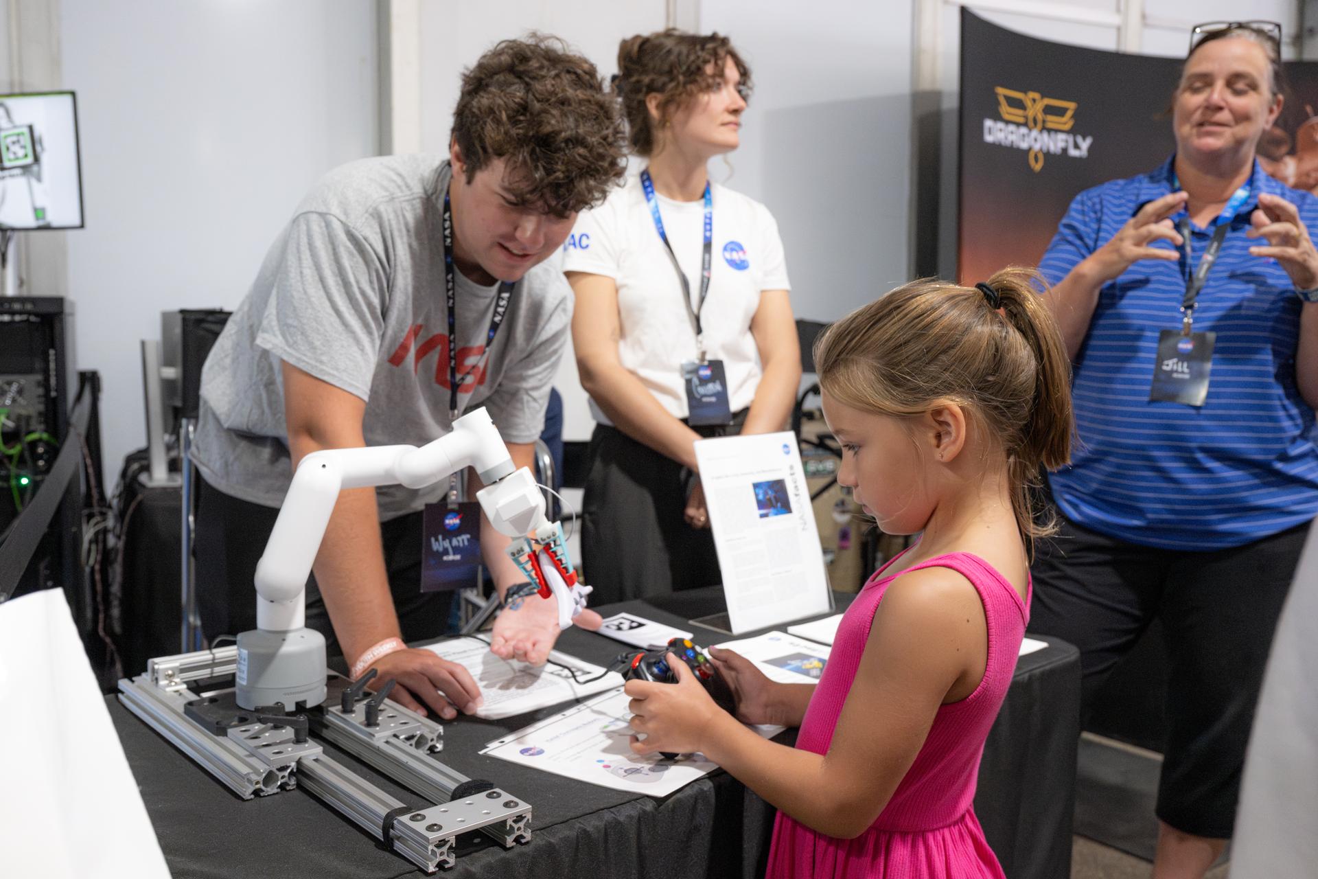 Air show attendees visit NASA's exhibit at EAA AirVenture Oshkosh, Friday, July 24, 2026, at Wittman Regional Airport in Oshkosh, Wis. Photo Credit: (NASA/John Kraus)