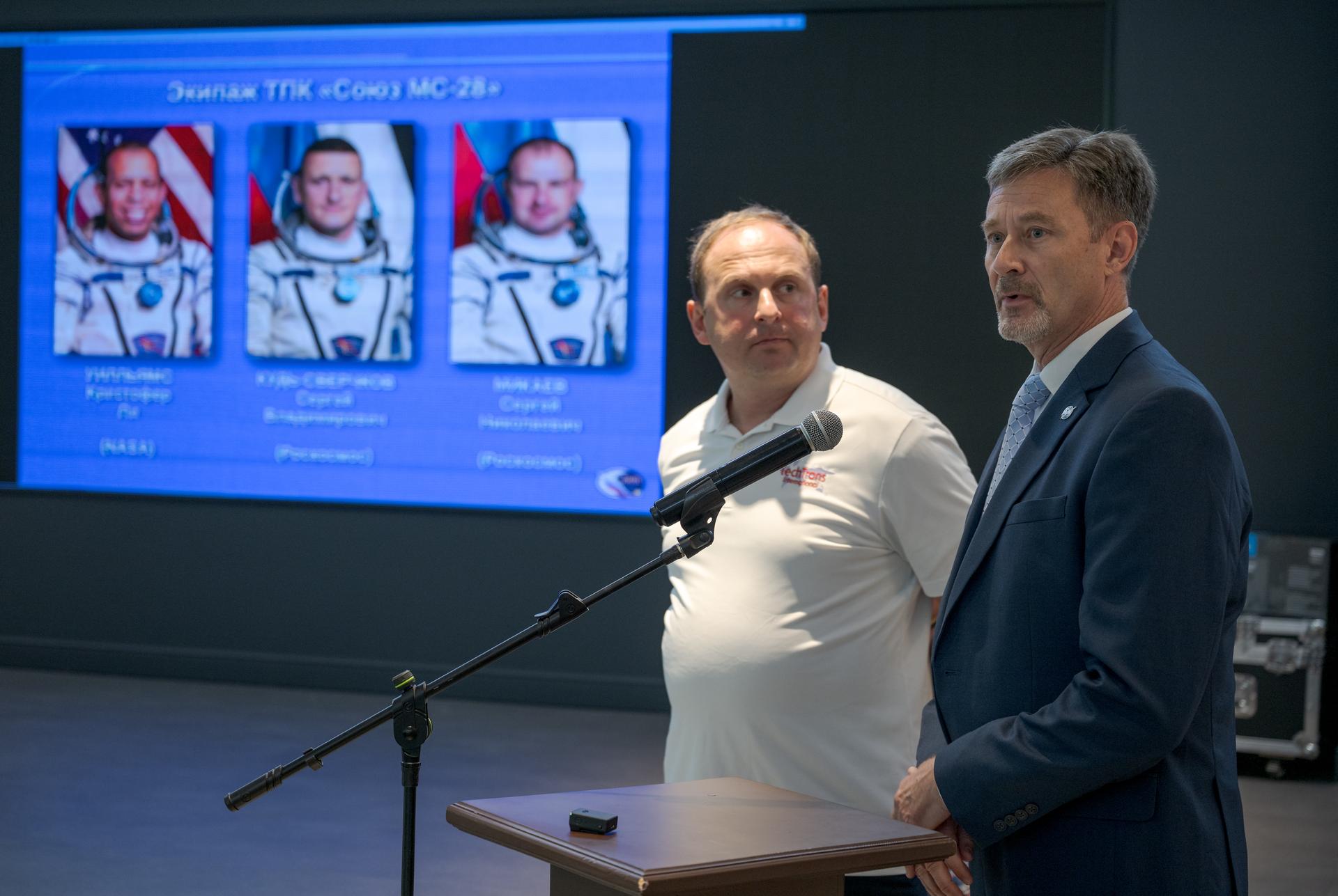 NASA Director for Human Space Flight Programs, Russia, Jay Marschke, right, supported by NASA Interpreter Ilya Shlepakov, reports as NASA, Roscosmos, and Russian Search and Recovery Forces meet at the Cosmonaut Hotel in Karaganda, Kazakhstan, Saturday, July 25, 2026, to discuss the readiness for the landing of Expedition 74 NASA astronaut Chris Williams, and Roscosmos cosmonauts Sergey Kud-Sverchkov, and Sergei Mikaev. Photo Credit: (NASA/Bill Ingalls)