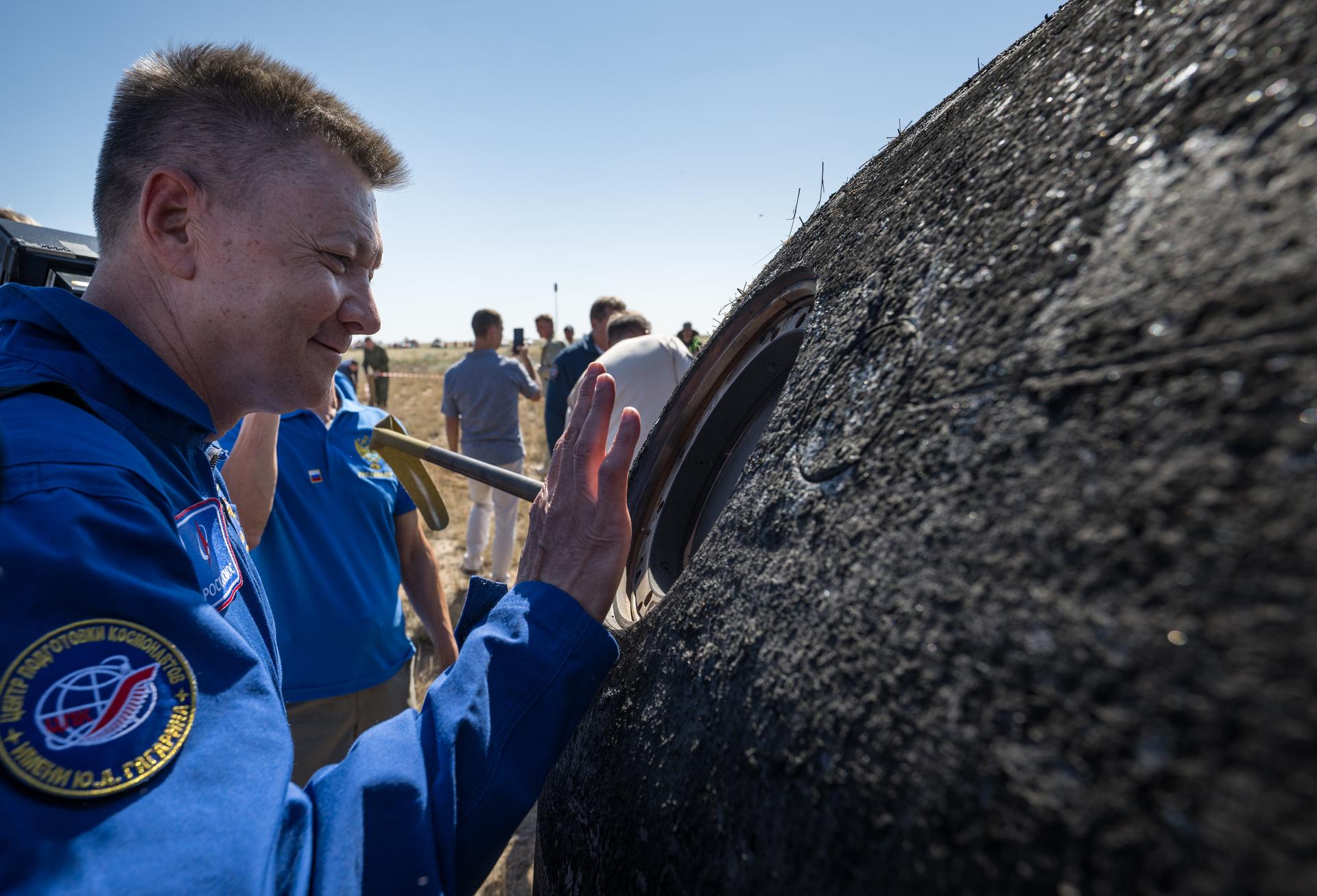 Head of Gargarin Cosmonaut Training Center Oleg Kononenko waves through a window of the Soyuz MS-28 spacecraft shortly after it landed in a remote area near the town of Zhezkazgan, Kazakhstan with  Expedition 74 NASA astronaut Chris Williams, and Roscosmos cosmonauts Sergey Kud-Sverchkov, and Sergei Mikaev aboard, Sunday, July 26, 2026. The trio returned to Earth after logging 241 days in space as a members of Expeditions 73 and 74 aboard the International Space Station. Photo Credit: (NASA/Bill Ingalls)