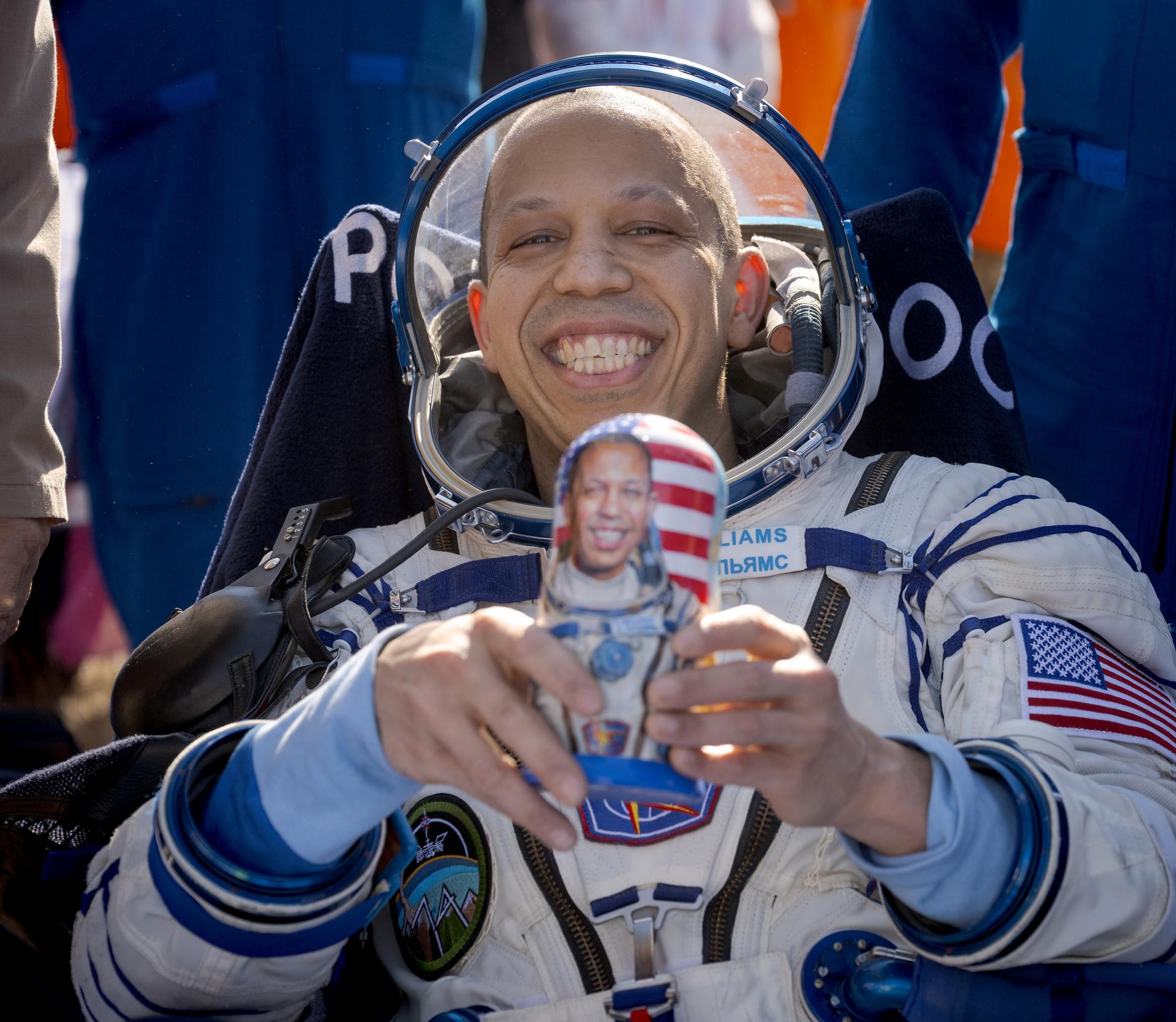 NASA astronaut Chris Williams holds a Matryoshka Doll gifted to him outside the Soyuz MS-28 spacecraft after he landed with Roscosmos cosmonauts Sergey Kud-Sverchkov, and Sergei Mikaev in a remote area near the town of Zhezkazgan, Kazakhstan on Sunday, July 26, 2026. The trio returned to Earth after logging 241 days in space as a members of Expeditions 73 and 74 aboard the International Space Station. Photo Credit: (NASA/Bill Ingalls)