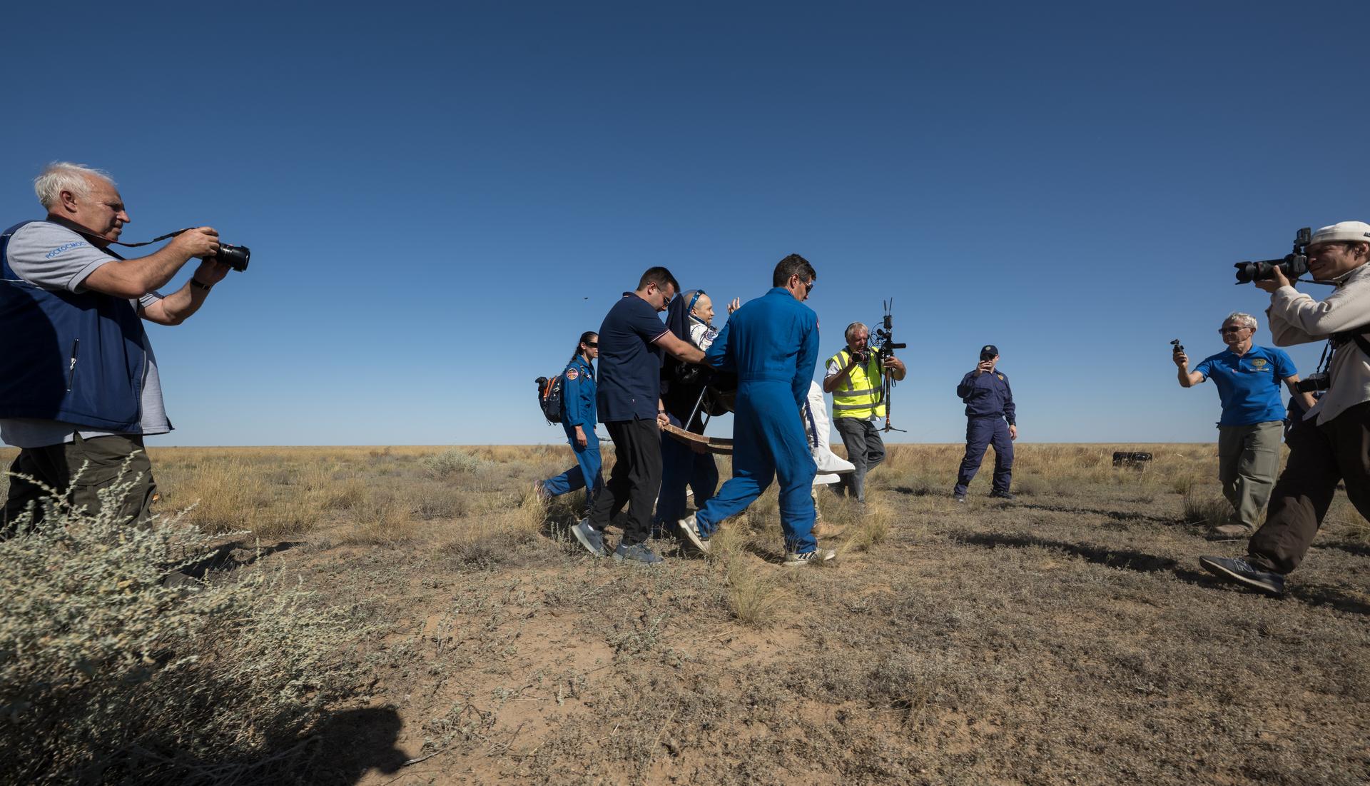 NASA astronaut Chris Williams is carried to a medical tent shortly after he and Roscosmos cosmonauts Sergey Kud-Sverchkov, and Sergei Mikaev landed in their Soyuz MS-28 spacecraft near the town of Zhezkazgan, Kazakhstan on Sunday, July 26, 2026. The trio returned to Earth after logging 241 days in space as a members of Expeditions 73 and 74 aboard the International Space Station. Photo Credit: (NASA/Bill Ingalls)