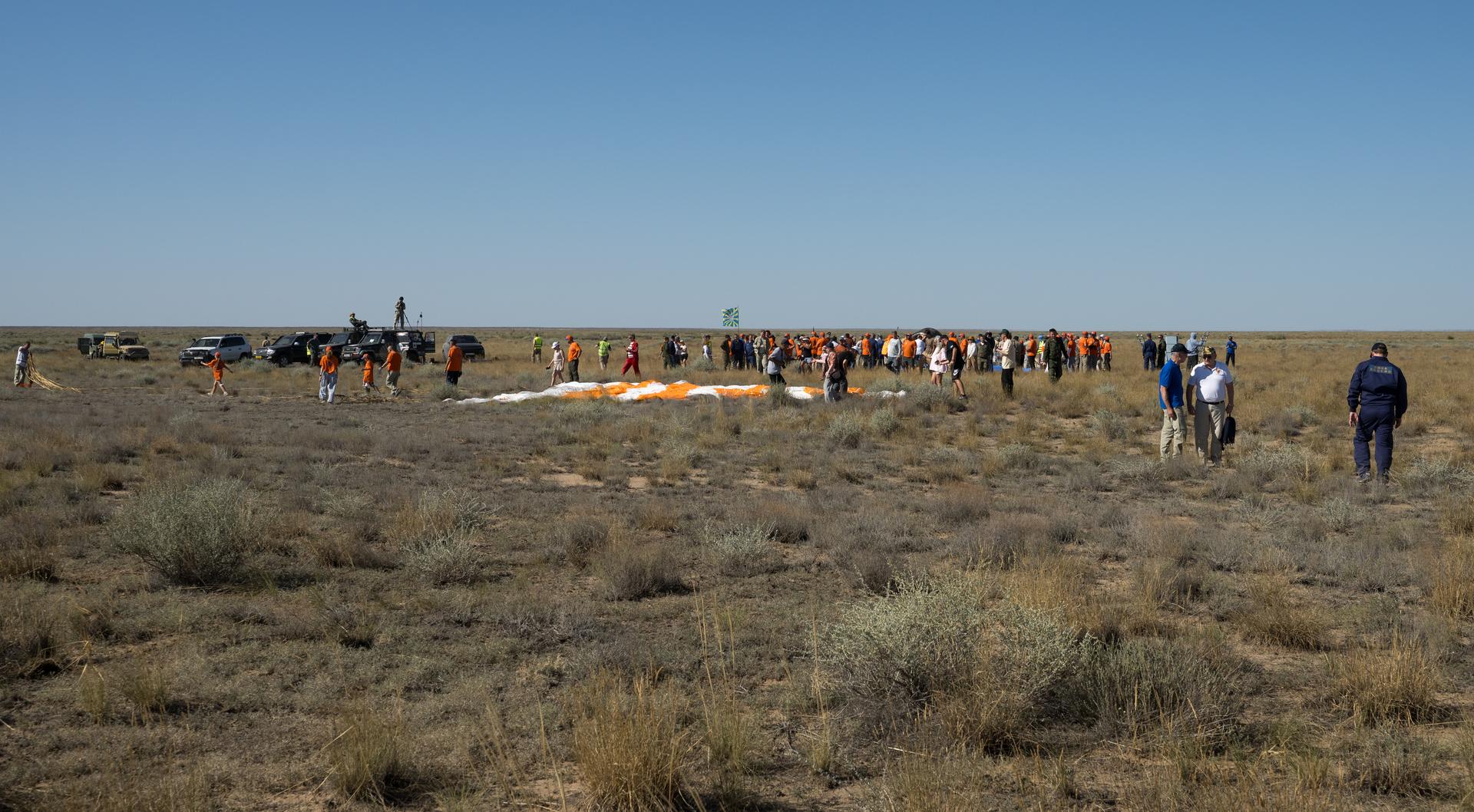 Russian Search and Rescue teams and tourist are seen at the Soyuz MS-28 spacecraft landing site in a remote area near the town of Zhezkazgan, Kazakhstan shortly after it landed with Expedition 74 NASA astronaut Chris Williams, and Roscosmos cosmonauts Sergey Kud-Sverchkov, and Sergei Mikaev aboard, Sunday, July 26, 2026. The trio returned to Earth after logging 241 days in space as a members of Expeditions 73 and 74 aboard the International Space Station. Photo Credit: (NASA/Bill Ingalls)