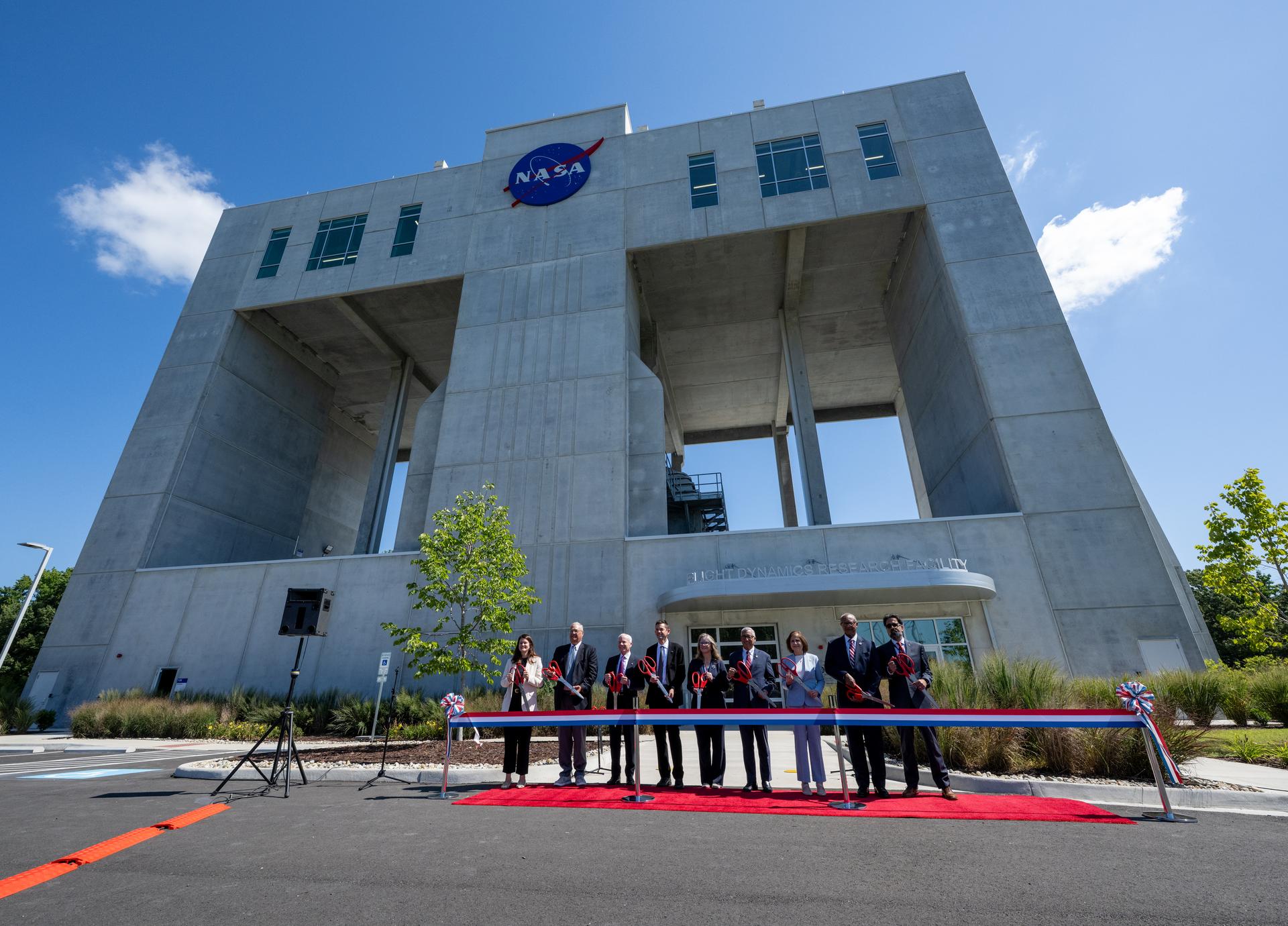 From left to right, Casey Swails, NASA Deputy Associate Administrator, Mike Waller, Vice President of BL Harbert International Federal Division, Edward C. Forst, Administrator of the General Services Administration, NASA Administrator Jared Isaacman, Dr. Trina Dyal, director of NASA's Langley Research Center, Congressman Robert “Bobby” Scott (D-Va.), Virginia Lt. Governor Ghazala F. Hashmi, City of Hampton Mayor Jimmy Gray, and Amit Kshatriya, NASA Associate Administrator pose for a photo before cutting the ribbon to open the Flight Dynamics Research Facility, NASA's newest wind tunnel, Friday, July 31, 2026, at NASA’s Langley Research Center in Hampton, Virginia. The state-of-the-art facility will support research and technology development that will advance the agency’s aeronautics, exploration, and science goals, including establishing a sustained human presence on the lunar surface through the Artemis program and the development of a Moon Base. Photo Credit: (NASA/Keegan Barber)