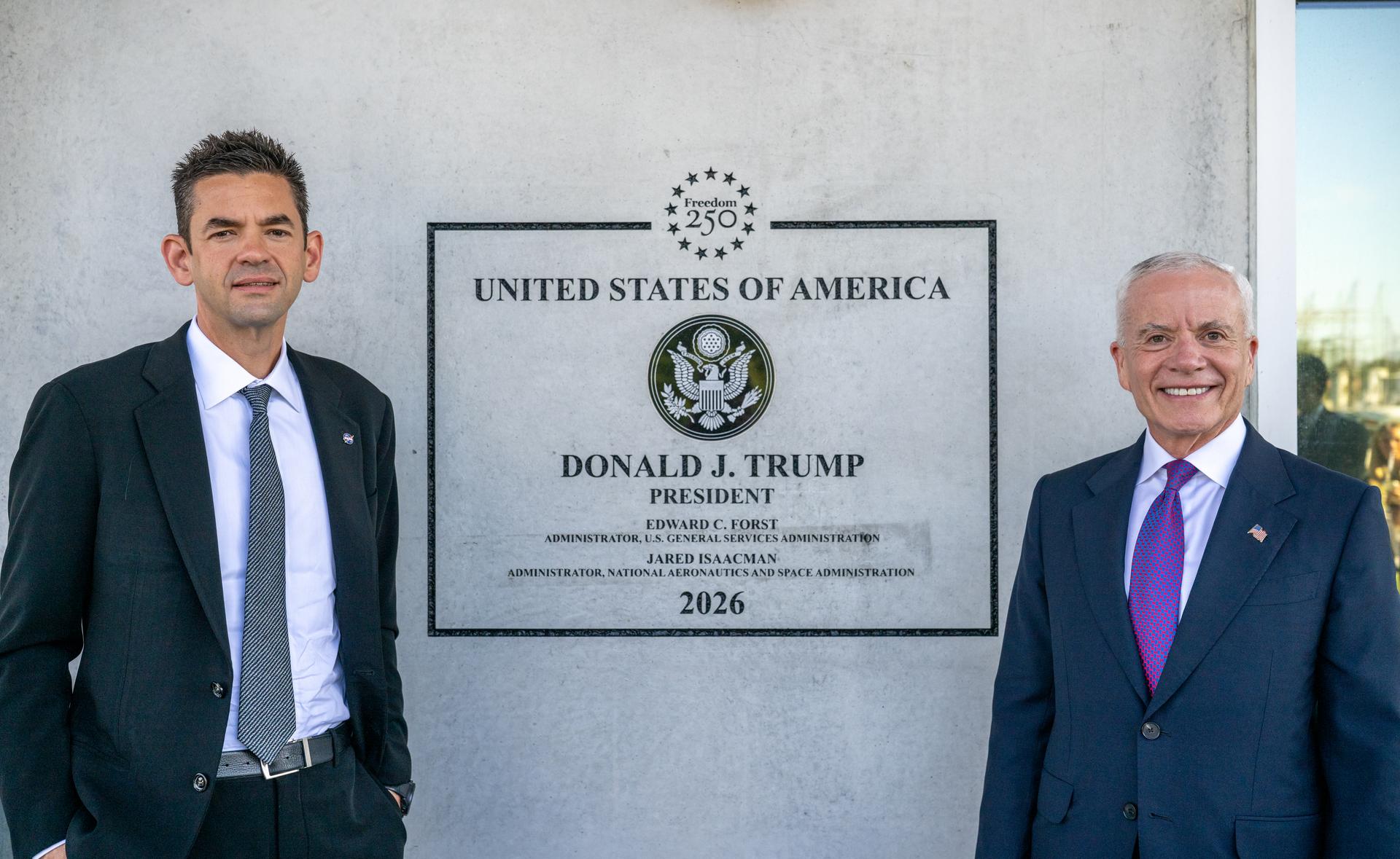 NASA Administrator Jared Isaacman, left, and Edward C. Forst, Administrator of the General Services Administration, right, pose for a photo beside a plaque at the Flight Dynamics Research Facility, NASA's newest wind tunnel, Friday, July 31, 2026, at NASA’s Langley Research Center in Hampton, Virginia. The state-of-the-art facility will support research and technology development that will advance the agency’s aeronautics, exploration, and science goals, including establishing a sustained human presence on the lunar surface through the Artemis program and the development of a Moon Base. Photo Credit: (NASA/Keegan Barber)