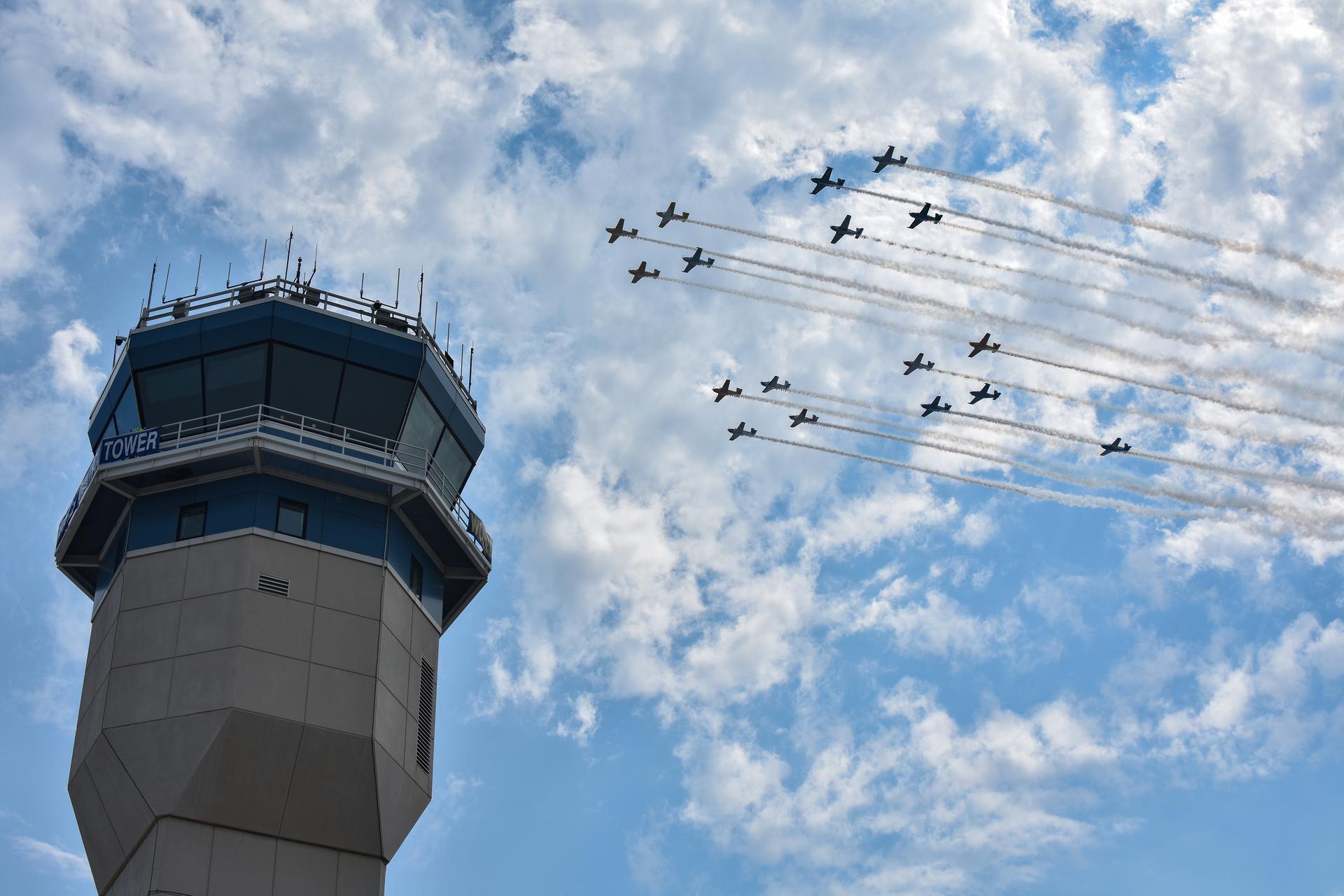 A formation is shown flying by the air traffic control tower at Wittman Regional Airport in Oshkosh, Wisconsin, for the 2026 Experimental Aircraft Association (EAA) AirVenture air show on Monday, July 20, 2026.