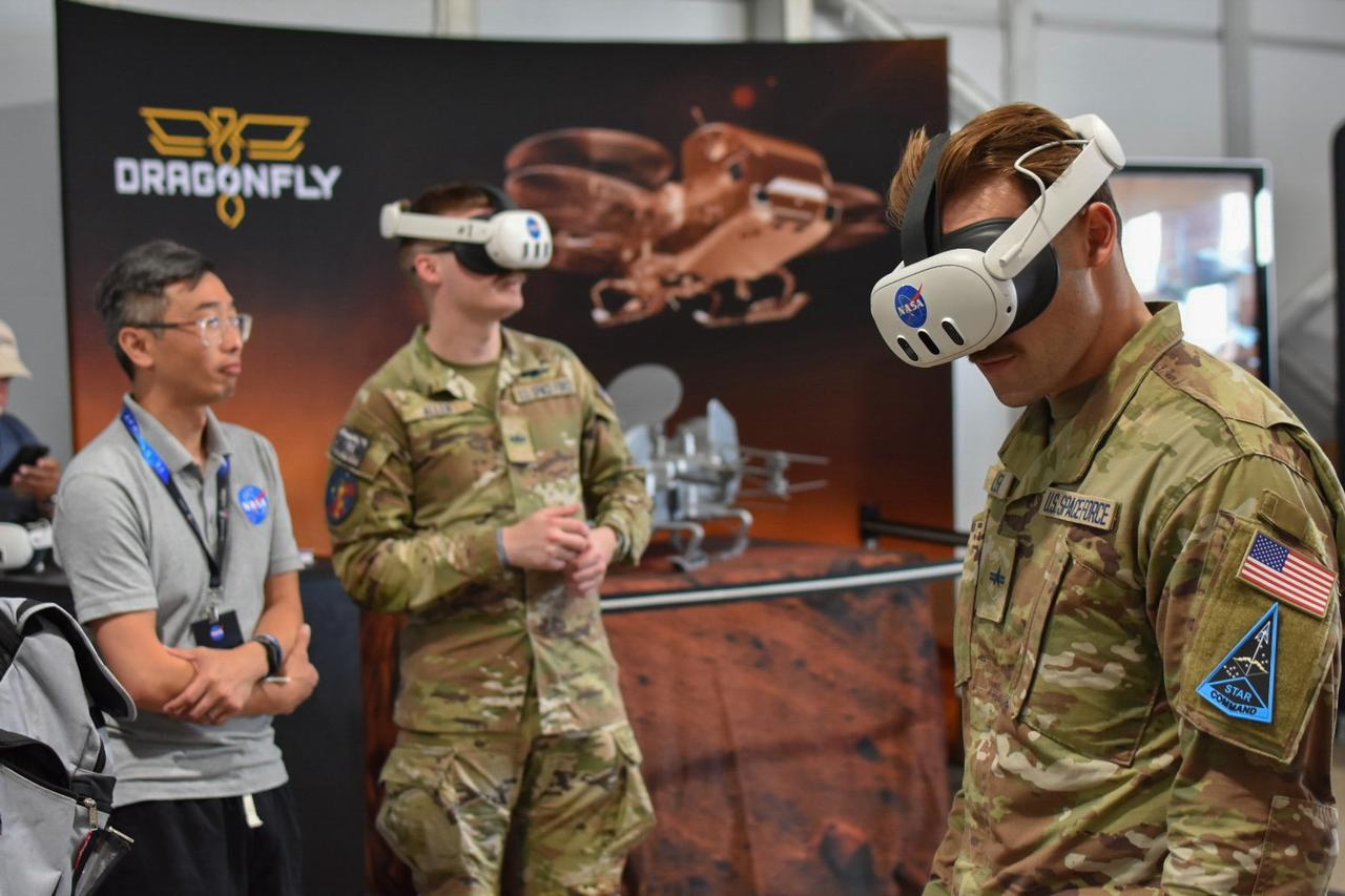 NASA Program Support Specialist David Lam shares a Dragonfly AR reality experience with Space Force service members in the NASA pavilion at the 2026 Experimental Aircraft Association (EAA) AirVenture air show in Oshkosh, Wisconsin, on Monday, July 20, 2026.