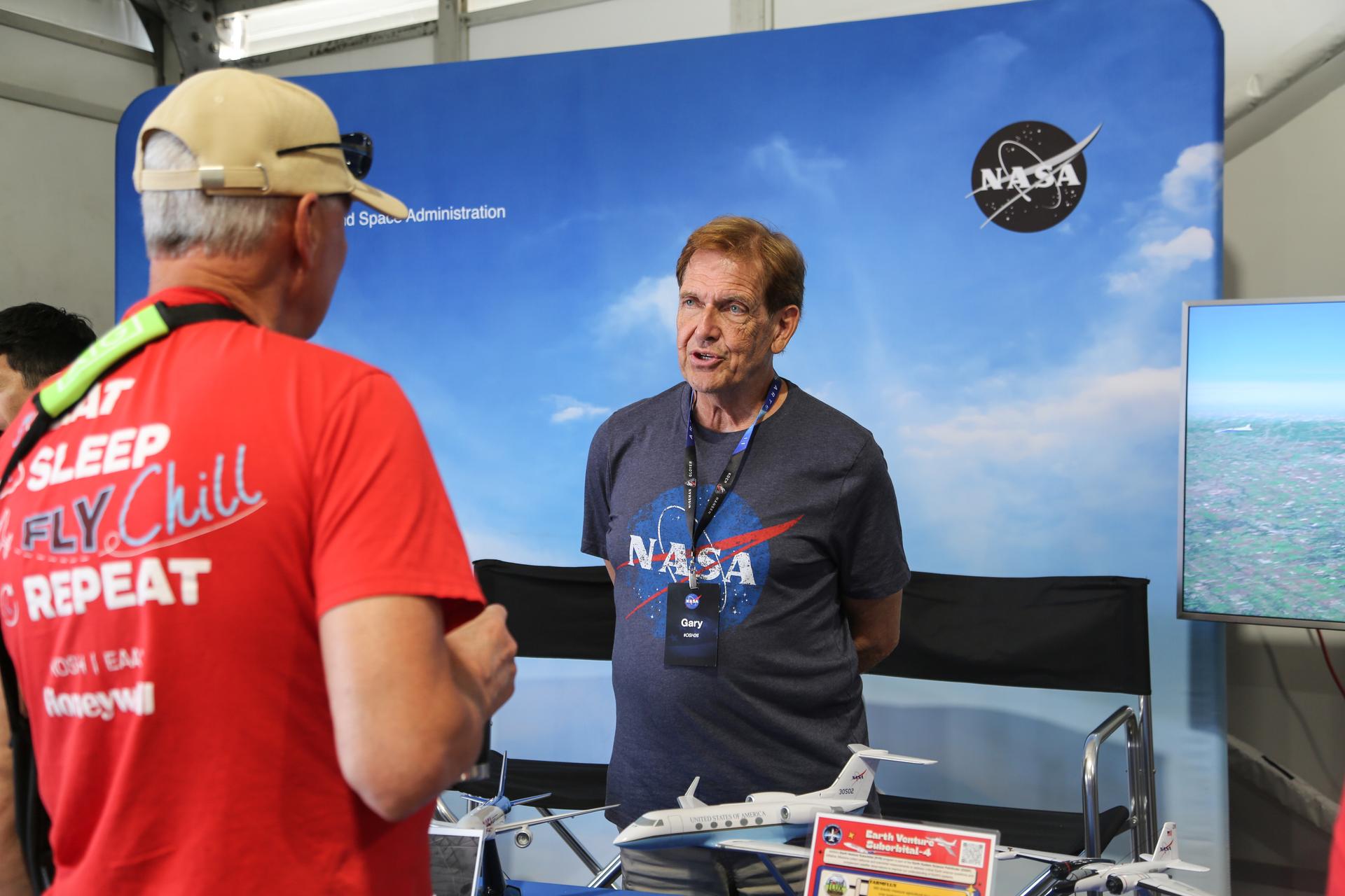 National Suborbital Research Center Program Director Gary Ash talks with a visitor to the Airborne Science display at the NASA pavilion at the 2026 Experimental Aircraft Association (EAA) AirVenture air show in Oshkosh, Wisconsin, on Monday, July 20, 2026.