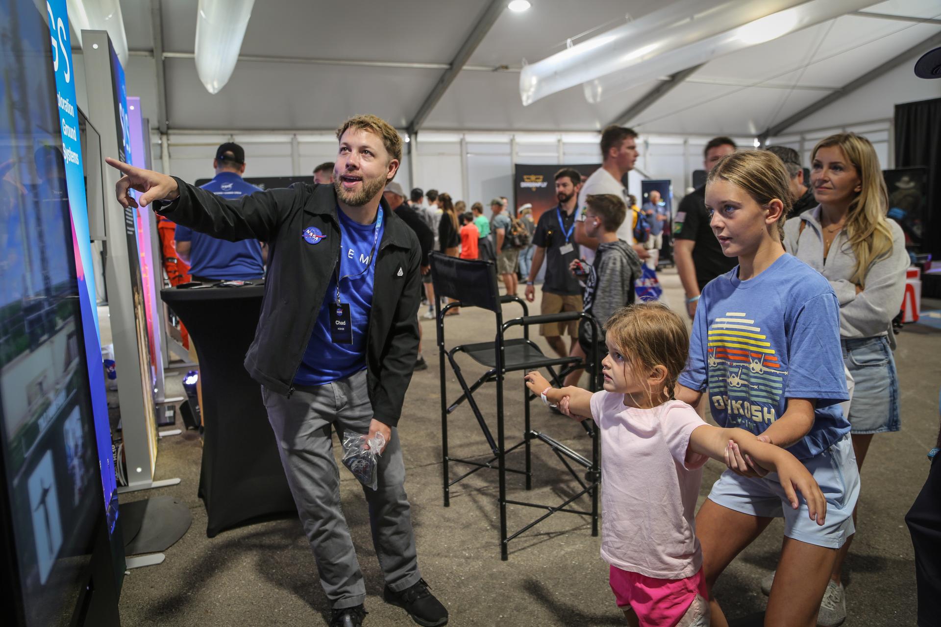 NASA Program Specialist Chad Siwik interacts with visitors at the Artemis exhibit in the NASA pavilion at the 2026 Experimental Aircraft Association (EAA) AirVenture air show in Oshkosh, Wisconsin, on Monday, July 20, 2026.
