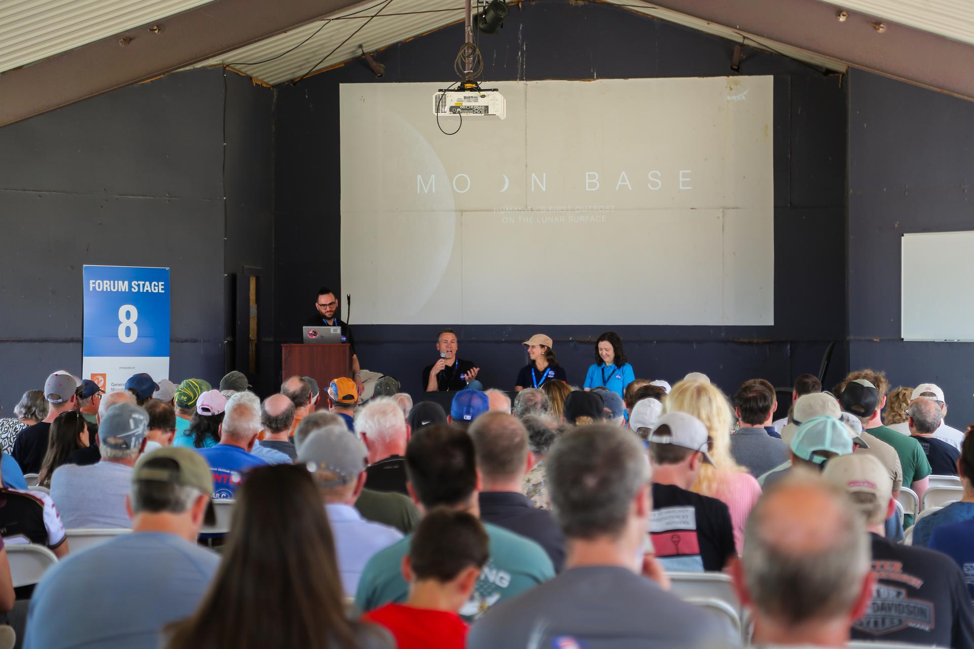 Moon Base Program Deputy Program Manager Jim Geffre speaks alongside Artemis and Moon Base Science and Utilization Manager Stephanie Dudley and Surface Mobility Deputy Lead Julia Badger during the forum presentation “Building Humanity’s First Moon Base” at the 2026 Experimental Aircraft Association (EAA) AirVenture air show in Oshkosh, Wisconsin, on Thursday, July 23, 2026.
