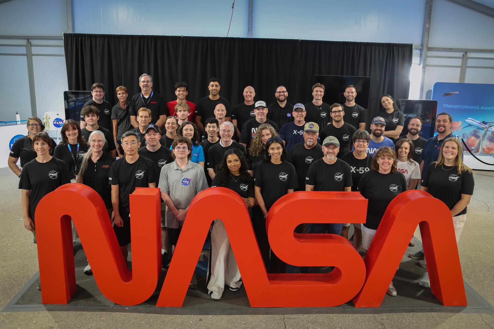 NASA pavilion staff pose for a group photo at the 2026 Experimental Aircraft Association (EAA) AirVenture air show in Oshkosh, Wisconsin, on Thursday, July 23, 2026.