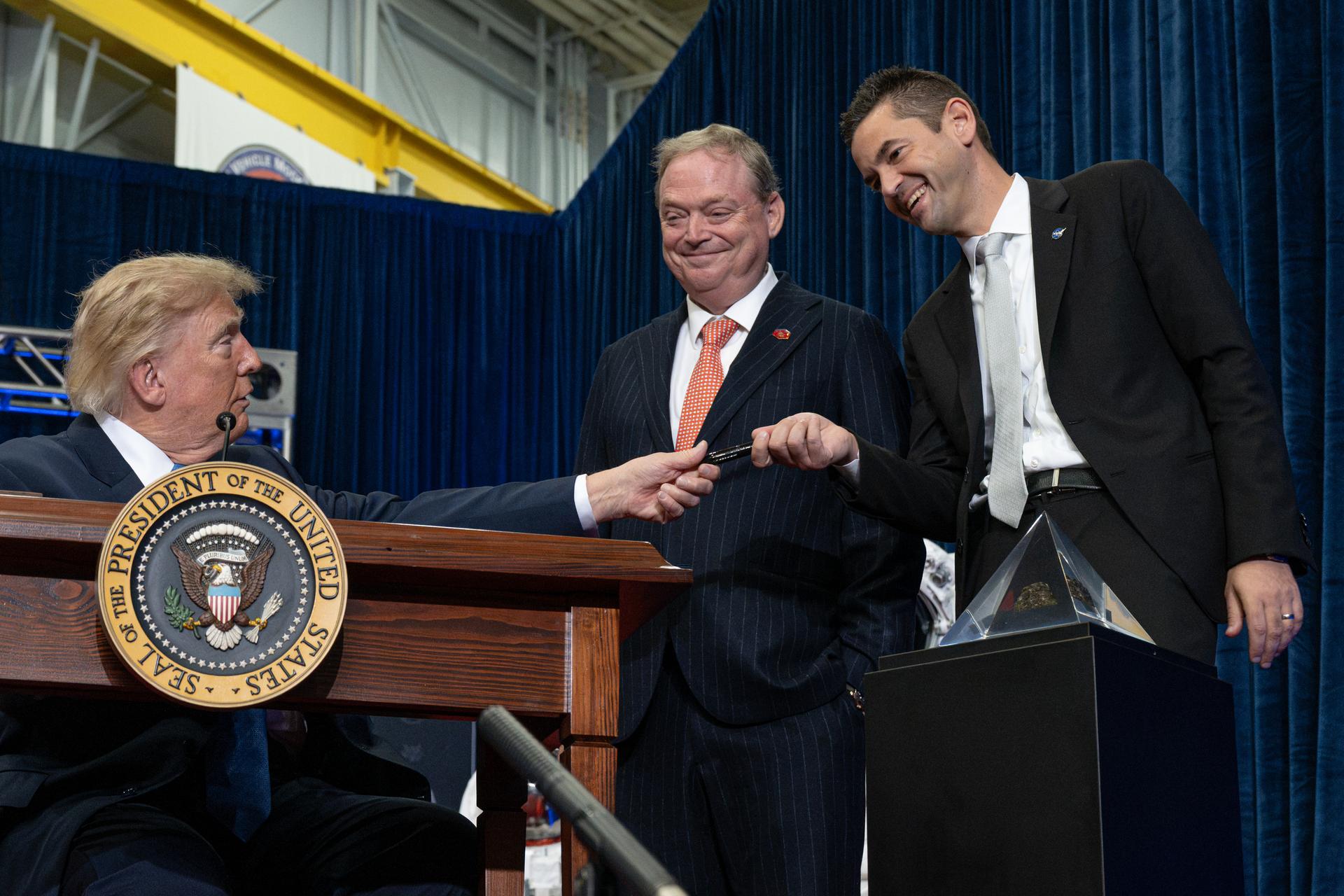 President Donald Trump hands NASA Administrator Jared Isaacman the pen used to sign the executive order establishing the United States Space Academy during an event to award the Congressional Space Medal of Honor to the Artemis II crew as Kevin Hassett, director of the National Economic Council, watches, Friday, Aug. 28, 2026, at NASA's Johnson Space Center in Houston, Texas. The Artemis II crew completed their approximately ten-day mission around the Moon in April 2026 and are the 31st, 32nd, 33rd, and 34th astronauts to receive the award. Photo Credit: (NASA/John Kraus)