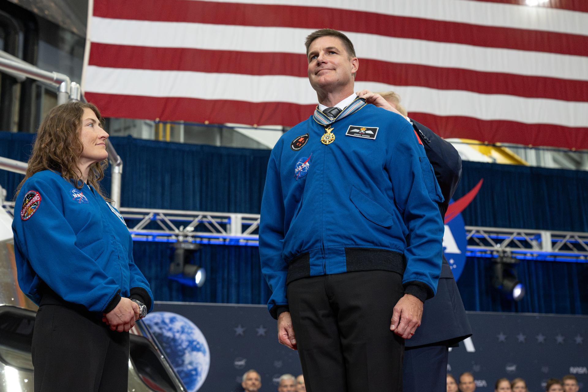 President Donald Trump awards the Congressional Space Medal of Honor to Artemis II mission specialist Canadian Space Agency astronaut Jeremy Hansen as NASA astronaut Artemis II mission specialist Christina Koch watches, Friday, Aug. 28, 2026, at Ellington Field Joint Reserve Base in Houston, Texas. The Artemis II crew completed their approximately ten-day mission around the Moon in April 2026 and are the 31st, 32nd, 33rd, and 34th astronauts to receive the award. Photo Credit: (NASA/John Kraus)