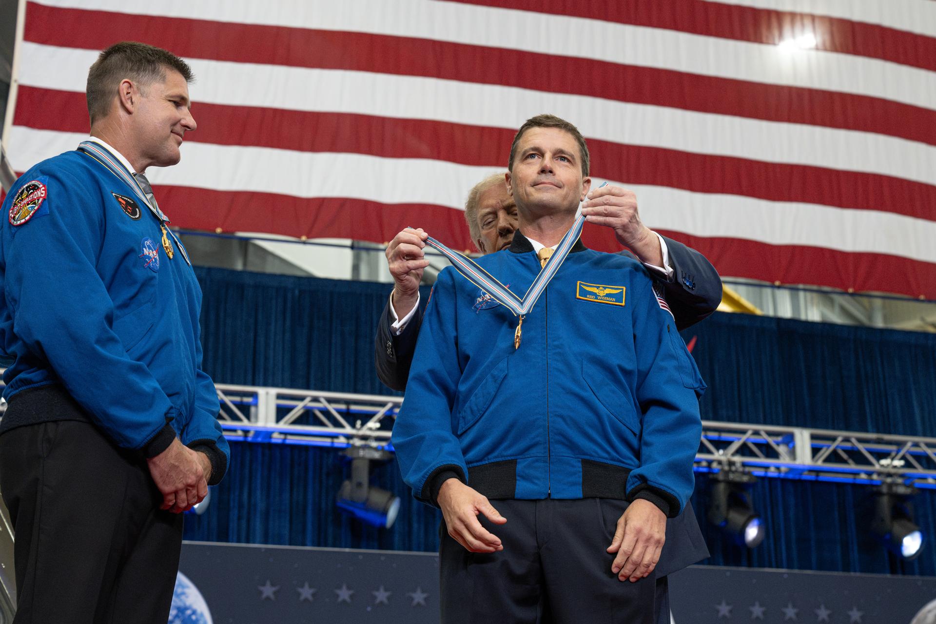 President Donald Trump awards the Congressional Space Medal of Honor to Artemis II commander NASA astronaut Reid Wiseman as Canadian Space Agency astronaut Artemis II mission specialist Jeremy Hansen watches, Friday, Aug. 28, 2026, at NASA's Johnson Space Center in Houston, Texas. The Artemis II crew completed their approximately ten-day mission around the Moon in April 2026 and are the 31st, 32nd, 33rd, and 34th astronauts to receive the award. Photo Credit: (NASA/John Kraus)