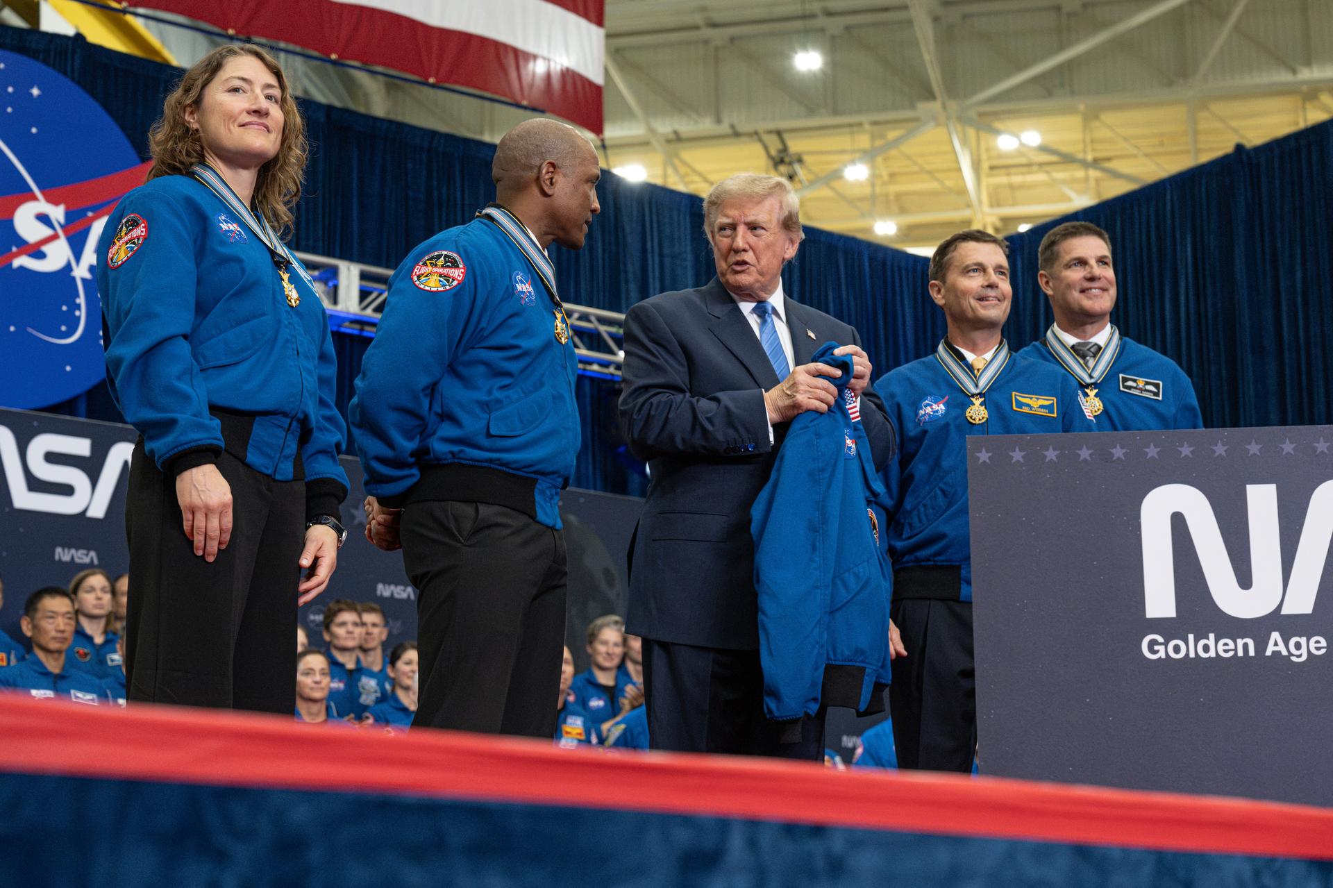 President Donald Trump recieves a NASA flight suit jacket from the Artemis II crew of NASA astronauts mission specialist Christina Koch, pilot Victor Glover, commander Reid Wiseman, and Canadian Space Agency astronaut mission specialist Jeremy Hansen during an event to award the Congressional Space Medal of Honor to the Artemis II crew, Friday, Aug. 28, 2026, at NASA's Johnson Space Center in Houston, Texas. The Artemis II crew completed their approximately ten-day mission around the Moon in April 2026 and are the 31st, 32nd, 33rd, and 34th astronauts to receive the award. Photo Credit: (NASA/John Kraus)