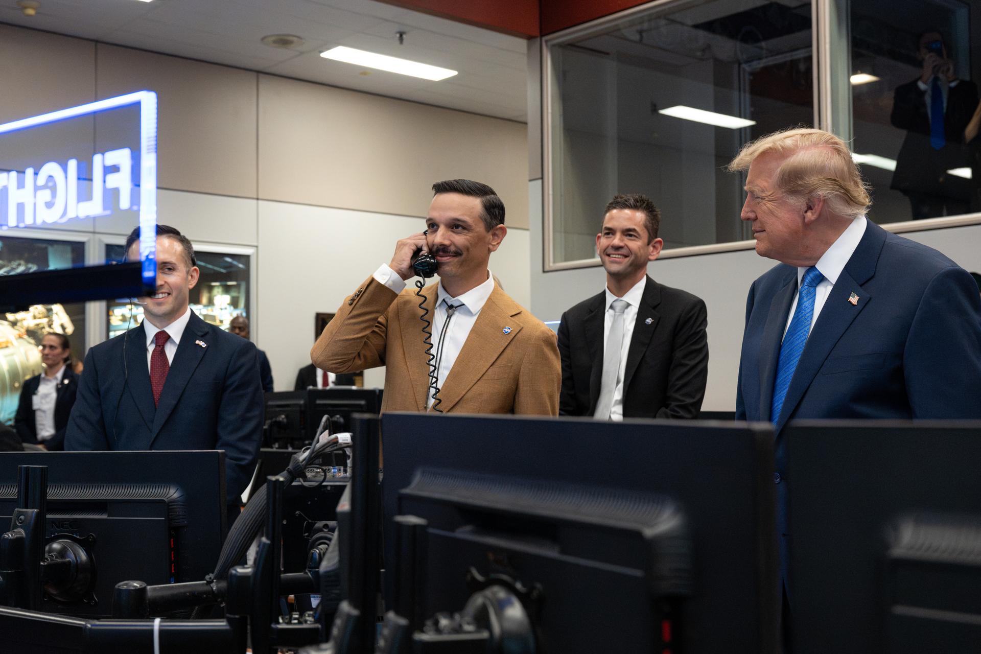President Donald Trump and NASA Administrator Jared Isaacman listen as Duke Brady, spouse of Expedition 75 crew member Jessica Meir, speaks with Expedition 75 crewmembers Jack Hathaway, Anil Menon, and Jessica Meir on board the International Space Station during a visit to the Christopher C. Kraft Jr. Mission Control Center, Friday, Aug. 28, 2026, at NASA’s Johnson Space Center in Houston, Texas. Photo Credit: (NASA/John Kraus)