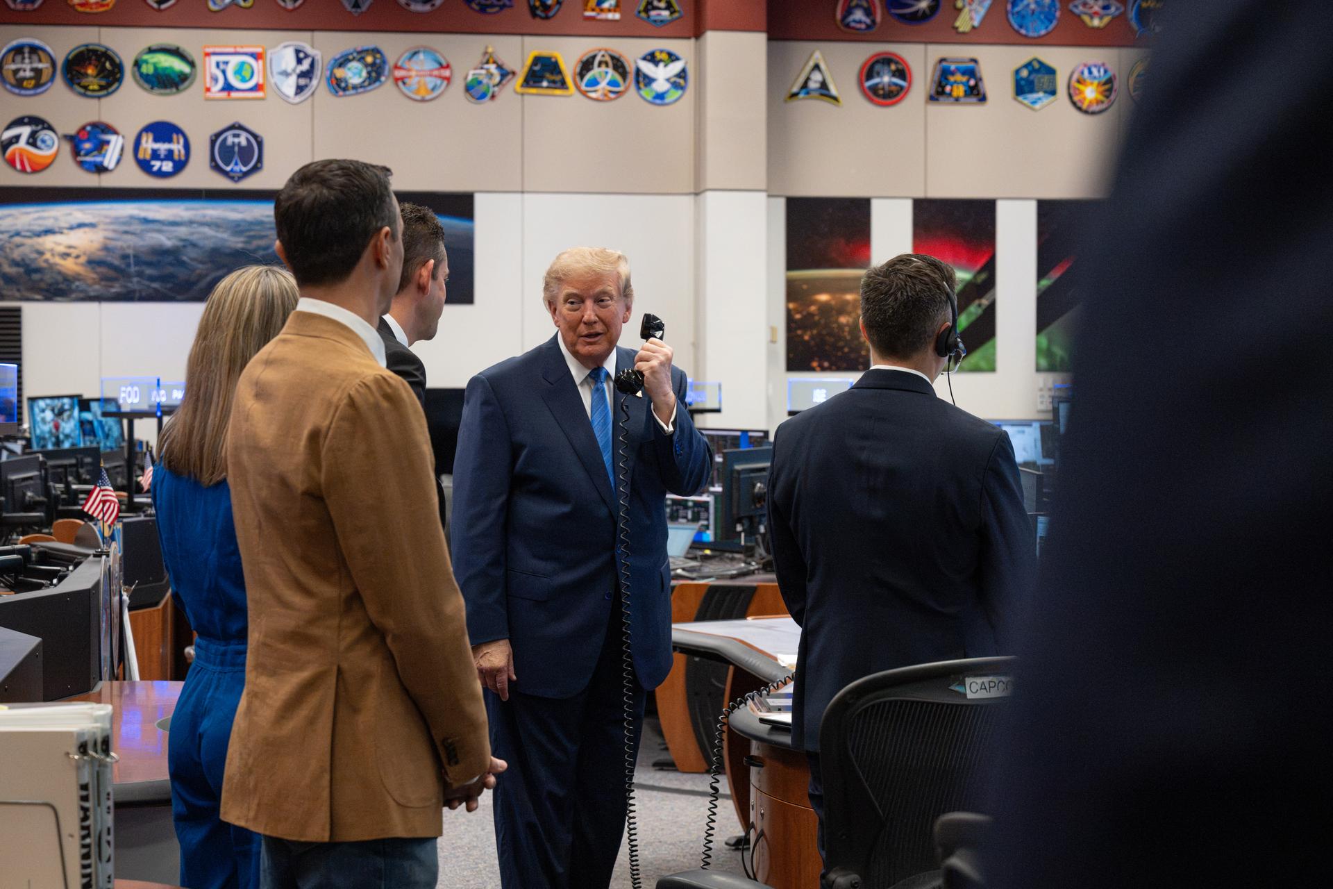 President Donald Trump speaks with Expedition 75 crewmembers Jack Hathaway, Anil Menon, and Jessica Meir on board the International Space Station during a visit to the Christopher C. Kraft Jr. Mission Control Center as NASA Administrator Jared Isaacman and Expedition 75 spouses Duke Brady and NASA astronaut candidate Anna Menon listen, Friday, Aug. 28, 2026, at NASA’s Johnson Space Center in Houston, Texas. Photo Credit: (NASA/John Kraus)