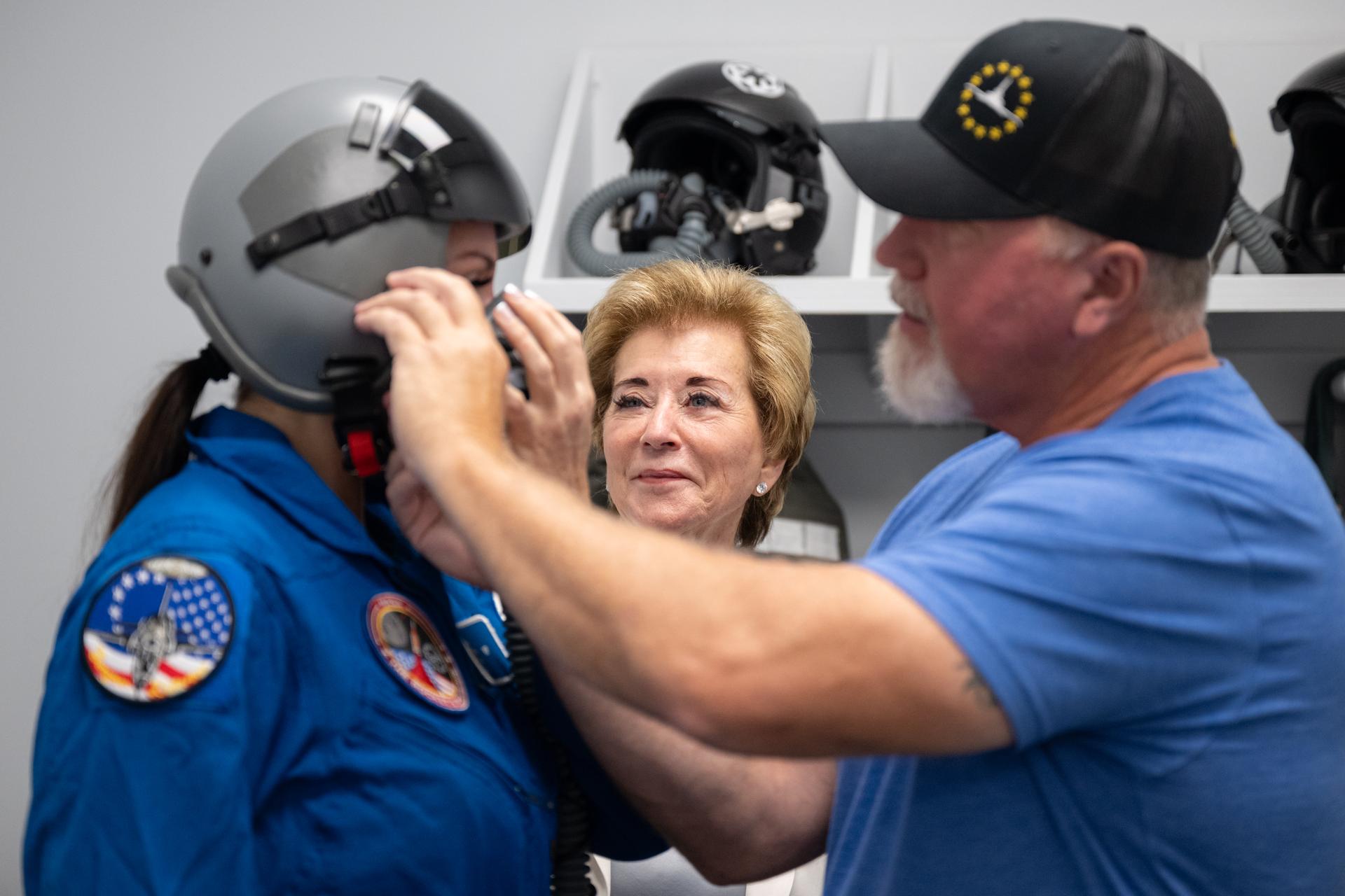 Secretary of Education Linda McMahon, center, watches as her daughter, Stephanie McMahon, left, is fitted in flight gear ahead of a flight in one of NASA Administrator Jared Isaacman's personal Alpha Jet aircraft, Saturday, Aug. 29, 2026, at NASA’s Kennedy Space Center in Florida. Photo Credit: (NASA/John Kraus)