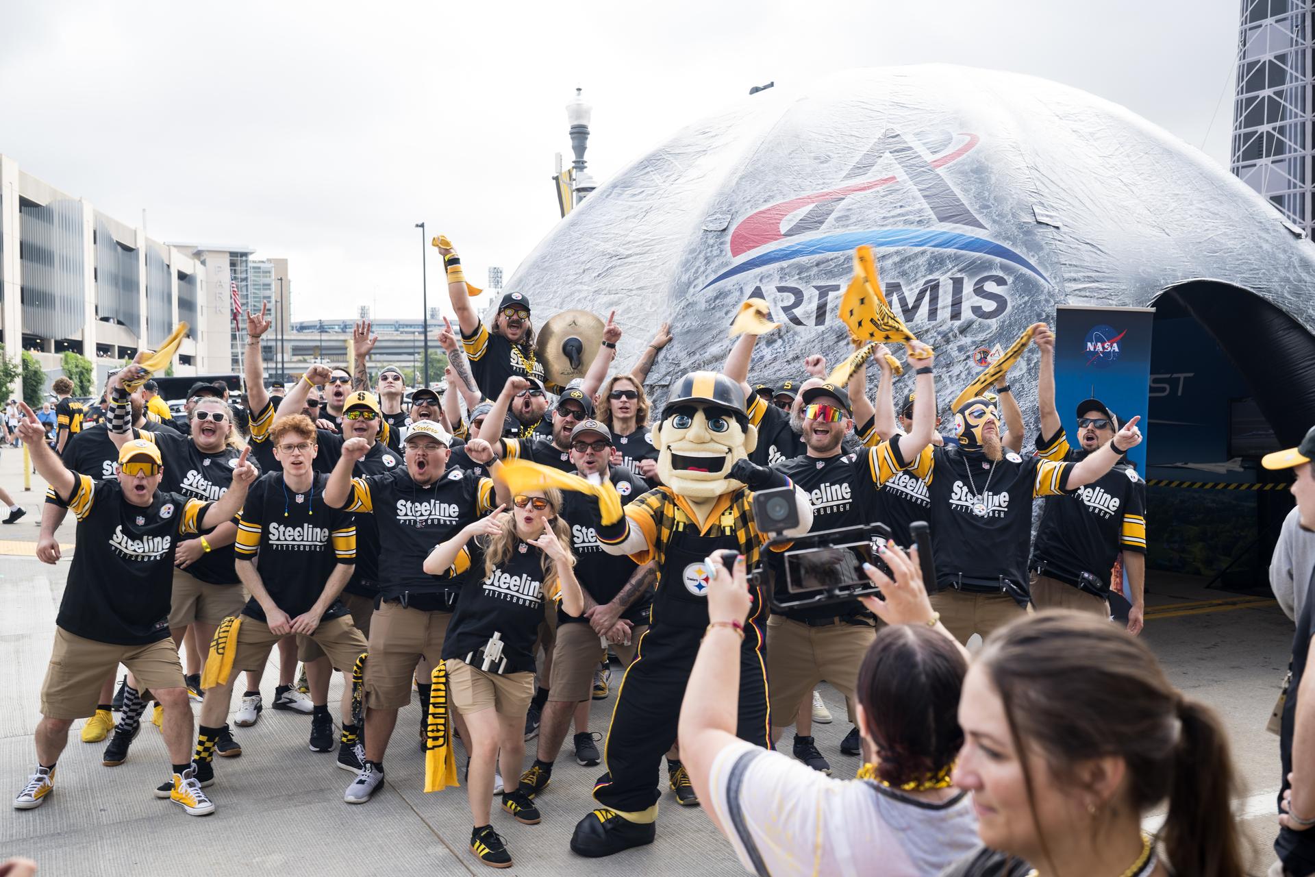 Pittsburgh Steeline, the independent, professional drumline that performs at Pittsburgh Steelers games is seen outside the NASA Experience Zone at an NFL game between the Pittsburgh Steelers and the Atlanta Falcons at Acrisure Stadium, Sunday, Sept. 13, 2026, in Pittsburgh, Pennsylvania. NASA’s engagement at NFL games is part of the agency's Inspiration Tour, aimed at strengthening connections between NASA and its partners and showcasing innovation in air and space in the lead up to the MAX POWER aerospace technology expo and airshow at the agency's Kennedy Space Center in early November. Photo Credit: (NASA/Aubrey Gemignani)