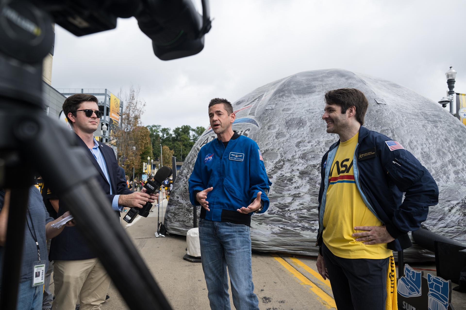 NASA Administrator Jared Isaacman and Anthony Vareha, NASA Flight Director at NASA’s Johnson Space Center are interviewed by media outside the NASA Experience Zone at an NFL game between the Pittsburgh Steelers and the Atlanta Falcons at Acrisure Stadium, Sunday, Sept. 13, 2026, in Pittsburgh, Pennsylvania. NASA’s engagement at NFL games is part of the agency's Inspiration Tour, aimed at strengthening connections between NASA and its partners and showcasing innovation in air and space in the lead up to the MAX POWER aerospace technology expo and airshow at the agency's Kennedy Space Center in early November. Photo Credit: (NASA/Aubrey Gemignani)