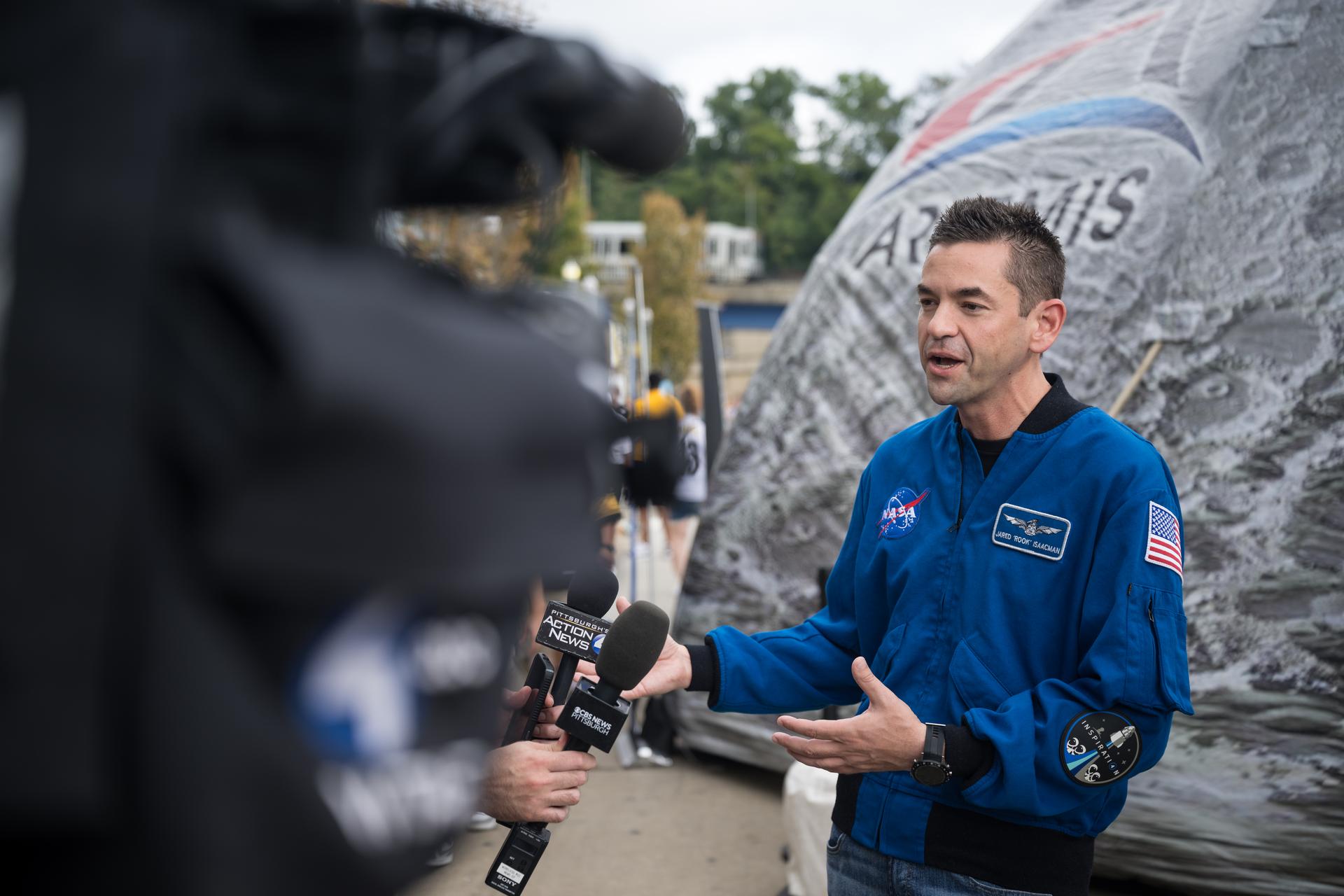 NASA Administrator Jared Isaacman is interviewed by media outside the NASA Experience Zone at an NFL game between the Pittsburgh Steelers and the Atlanta Falcons at Acrisure Stadium, Sunday, Sept. 13, 2026, in Pittsburgh, Pennsylvania. NASA’s engagement at NFL games is part of the agency's Inspiration Tour, aimed at strengthening connections between NASA and its partners and showcasing innovation in air and space in the lead up to the MAX POWER aerospace technology expo and airshow at the agency's Kennedy Space Center in early November. Photo Credit: (NASA/Aubrey Gemignani)